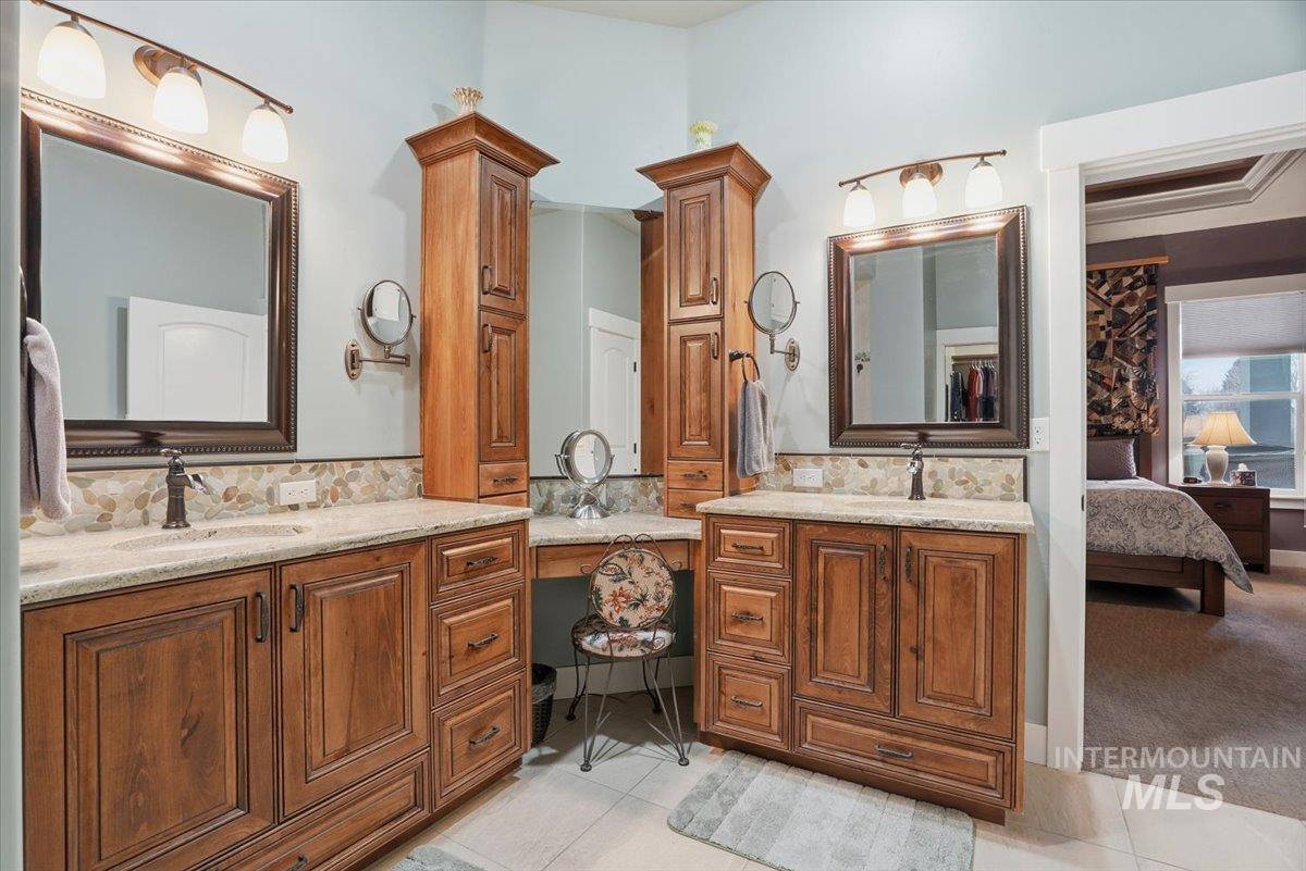 Full bathroom with two vanities, light tile patterned flooring, connected bathroom, and decorative backsplash
