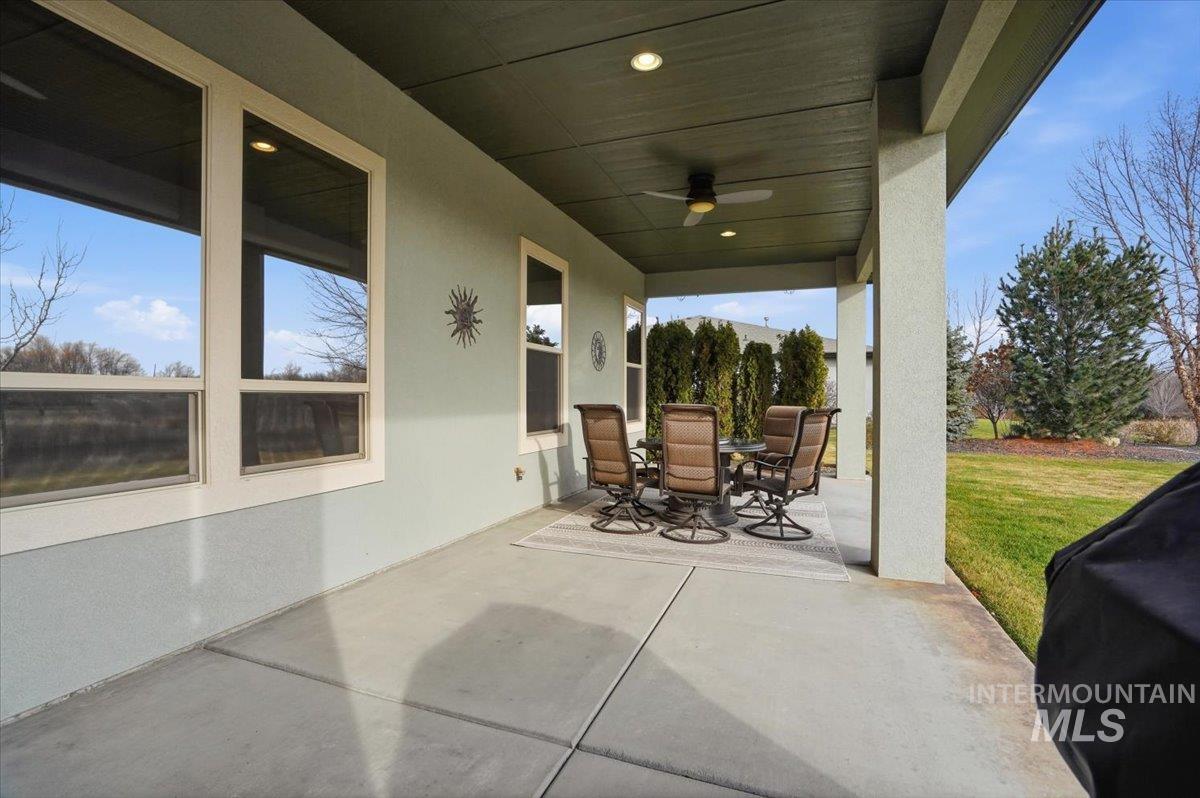 View of patio with outdoor dining space, a ceiling fan, and a grill