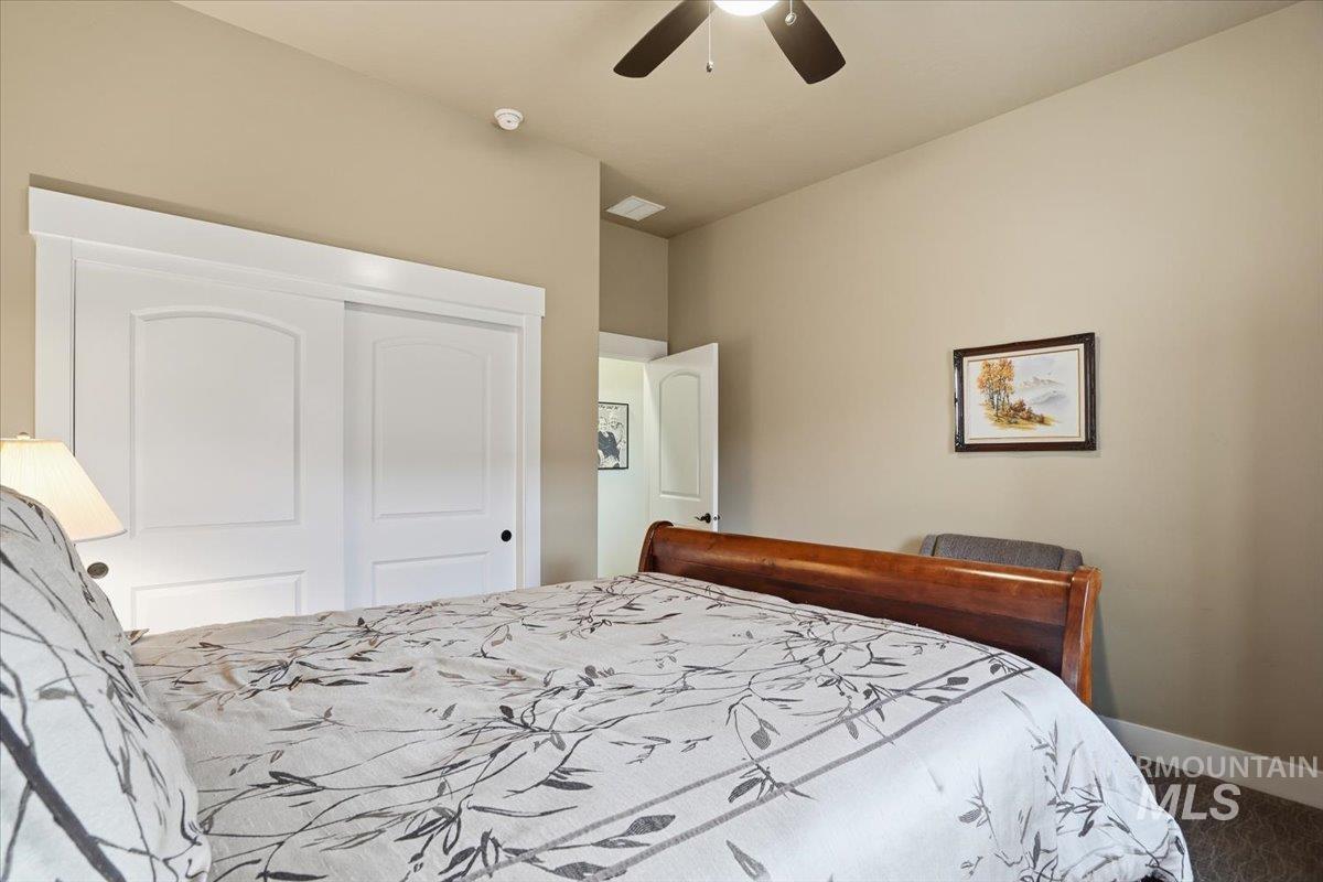 Carpeted bedroom featuring a closet and a ceiling fan