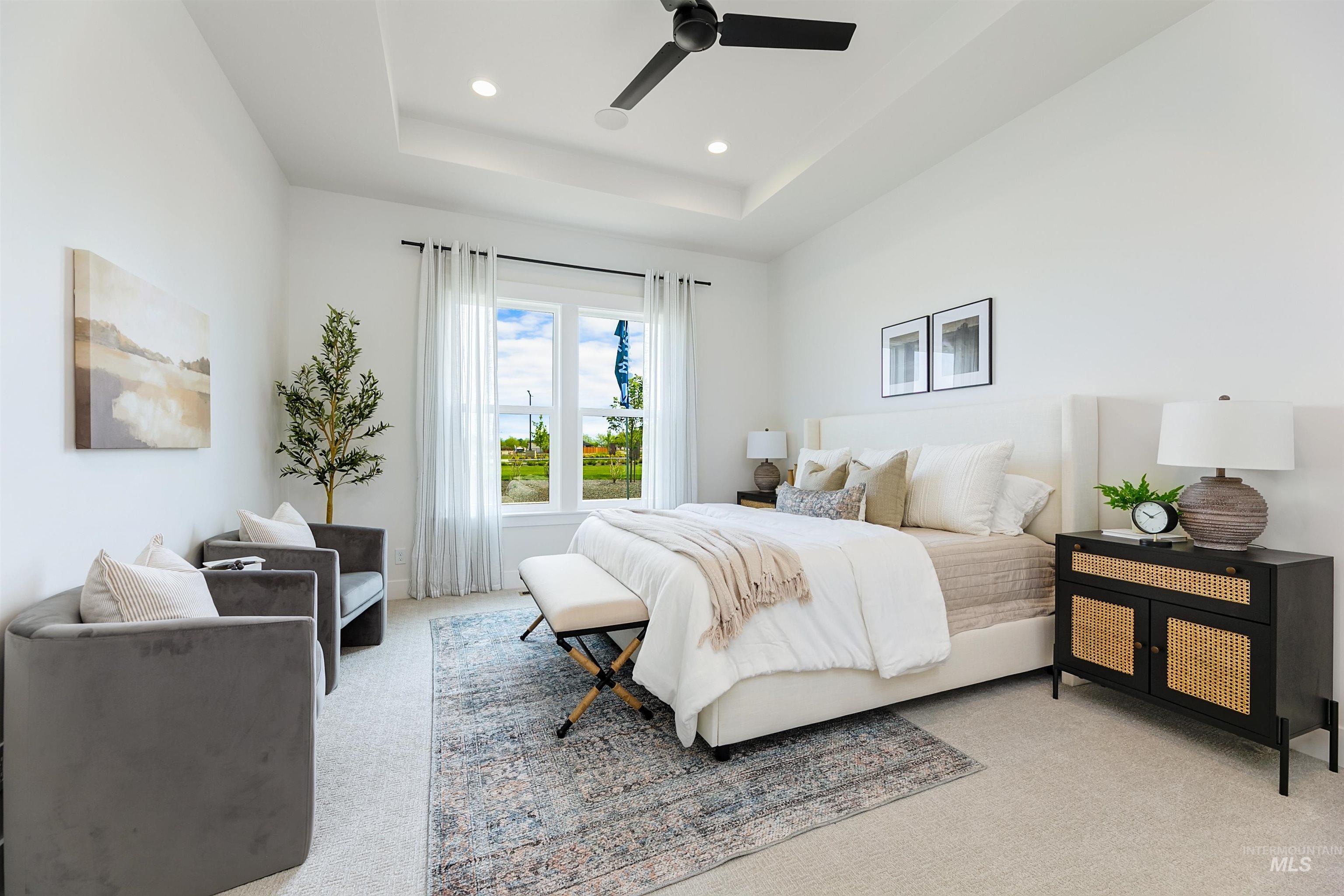 Bedroom with light carpet, a ceiling fan, recessed lighting, and a tray ceiling