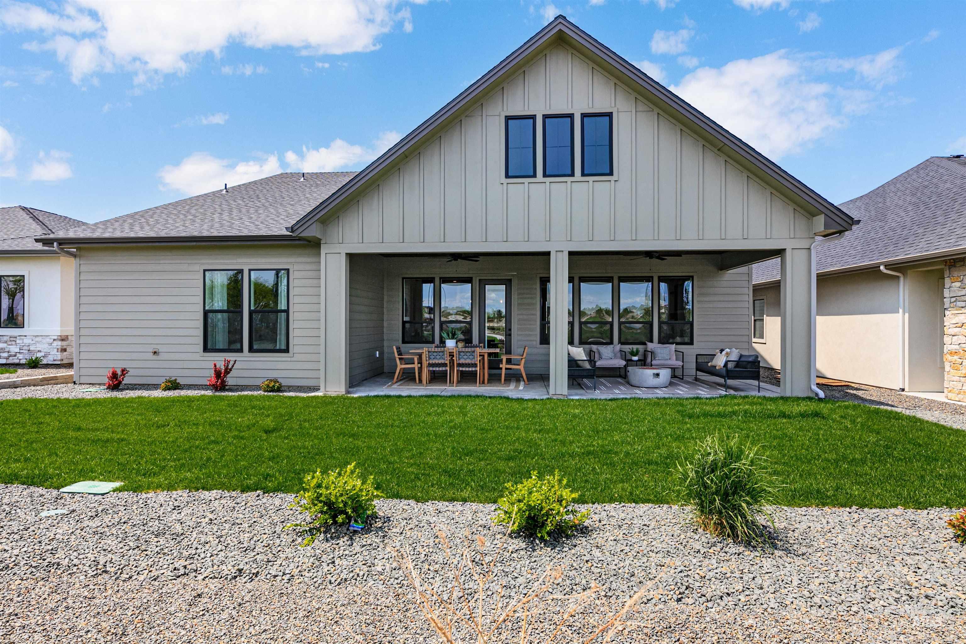 Rear view of property featuring ceiling fan, a patio, and board and batten siding