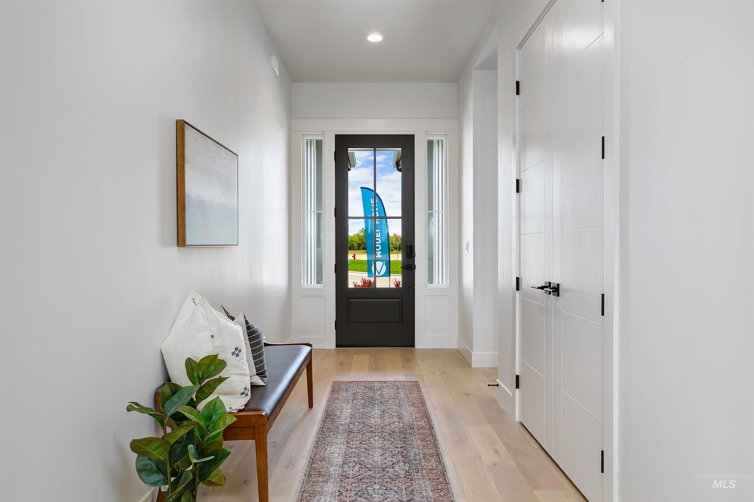 Foyer with light wood-style flooring and recessed lighting
