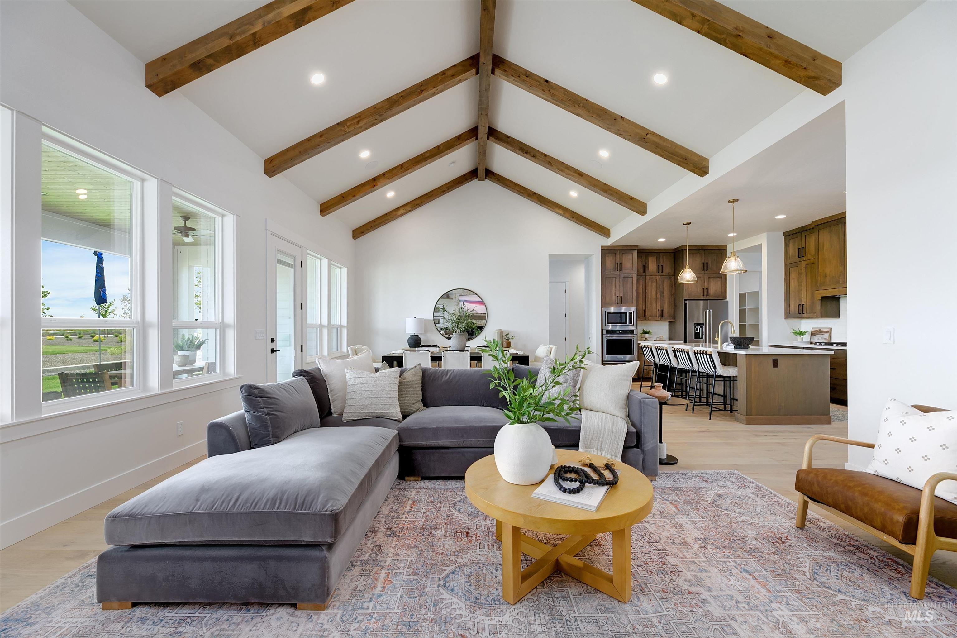 Living room featuring recessed lighting, light wood-type flooring, and a high ceiling