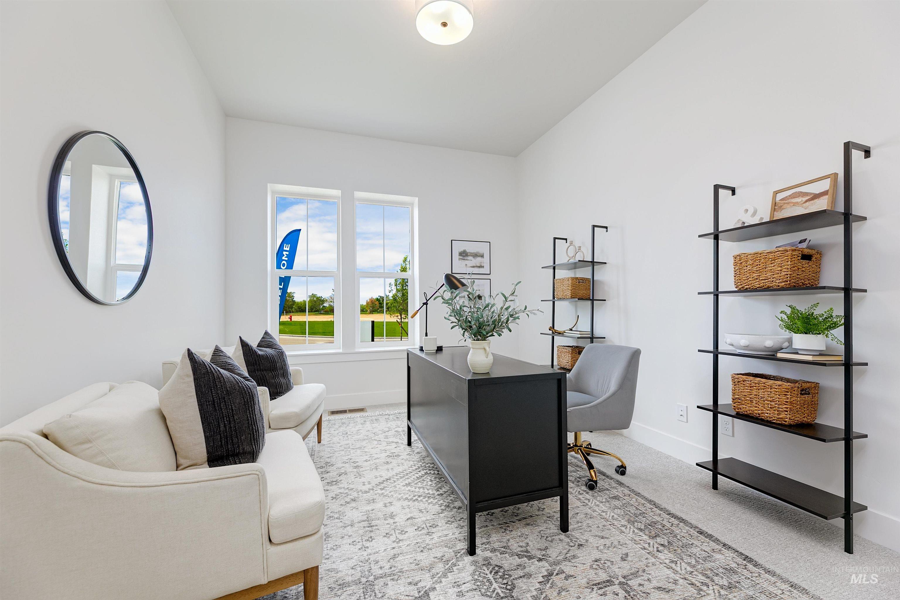 Office space featuring light carpet and lofted ceiling