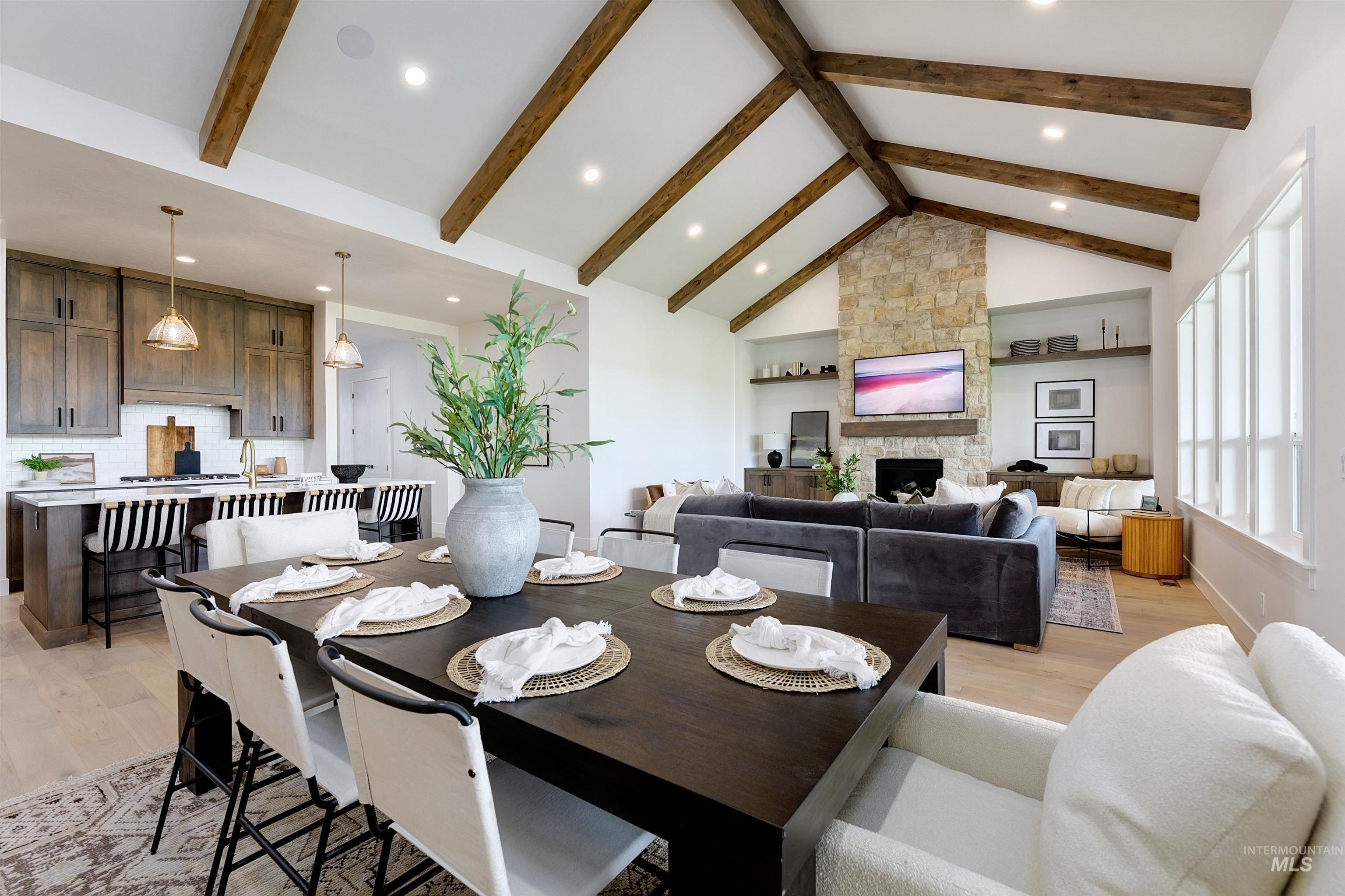Dining area with light wood-type flooring, recessed lighting, and a stone fireplace