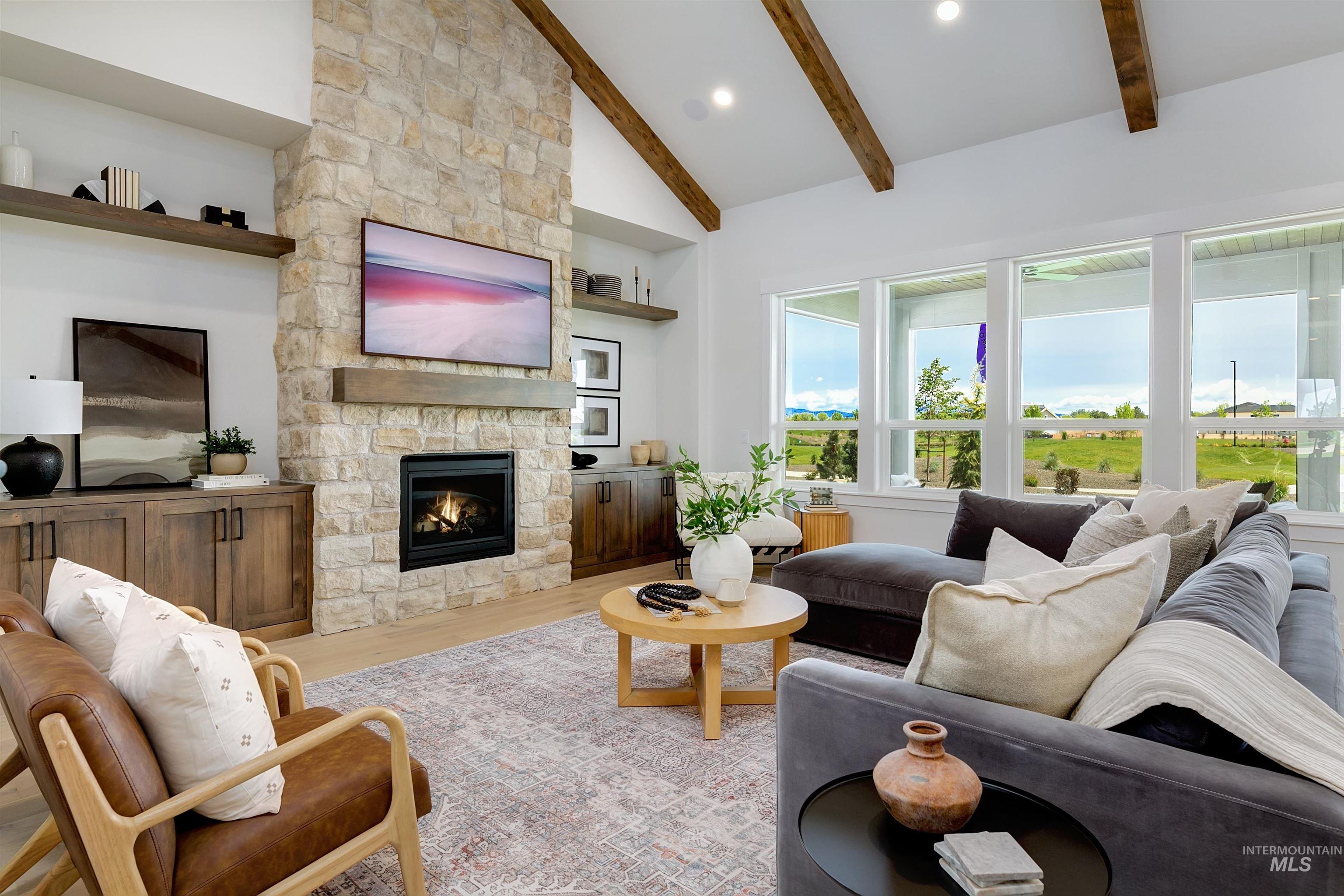 Living area featuring light wood-style flooring, a fireplace, vaulted ceiling, and recessed lighting