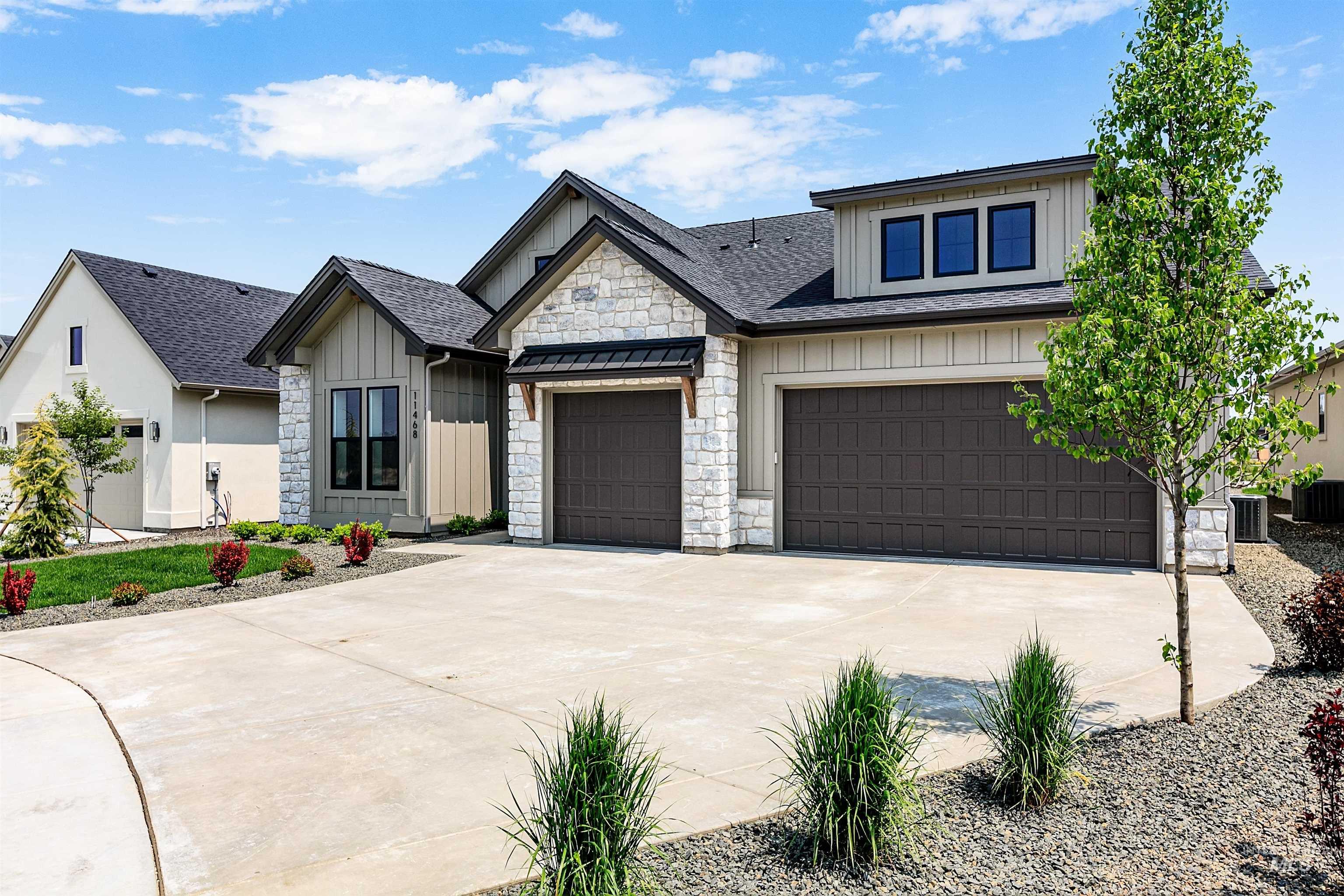 View of front of property featuring board and batten siding, driveway, and a shingled roof