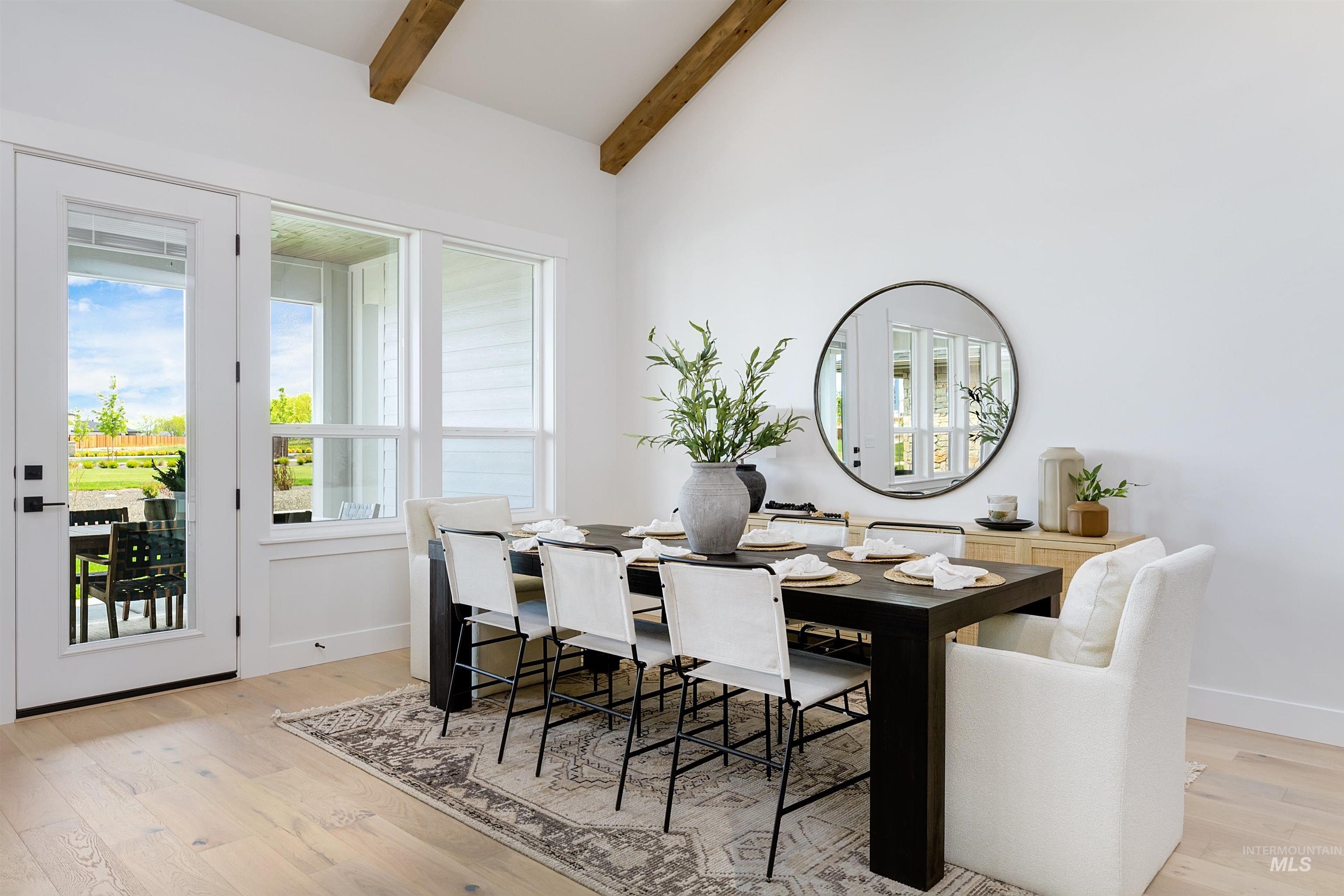 Dining area with light wood finished floors and vaulted ceiling