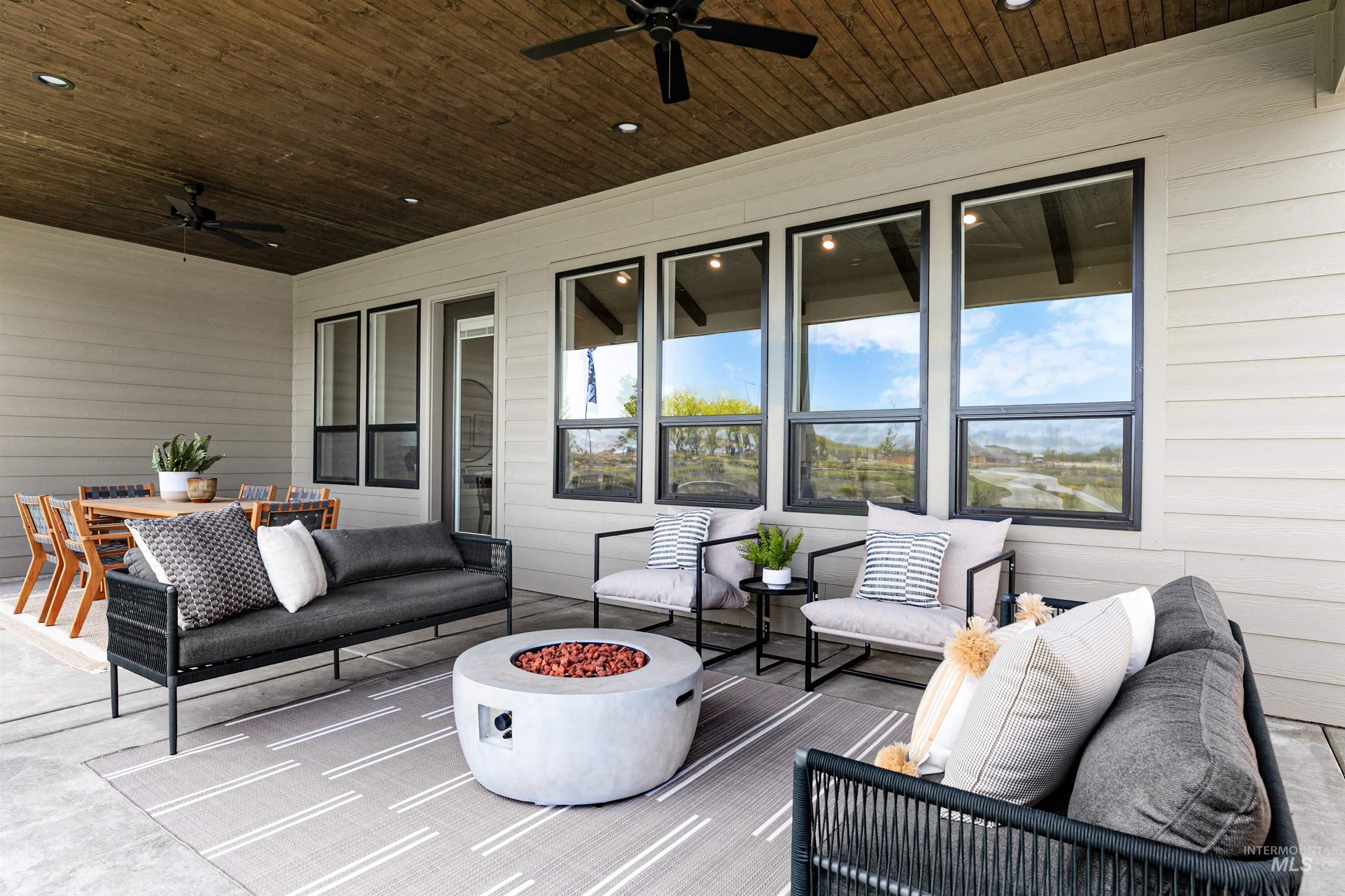 View of patio featuring an outdoor living space with a fire pit and ceiling fan