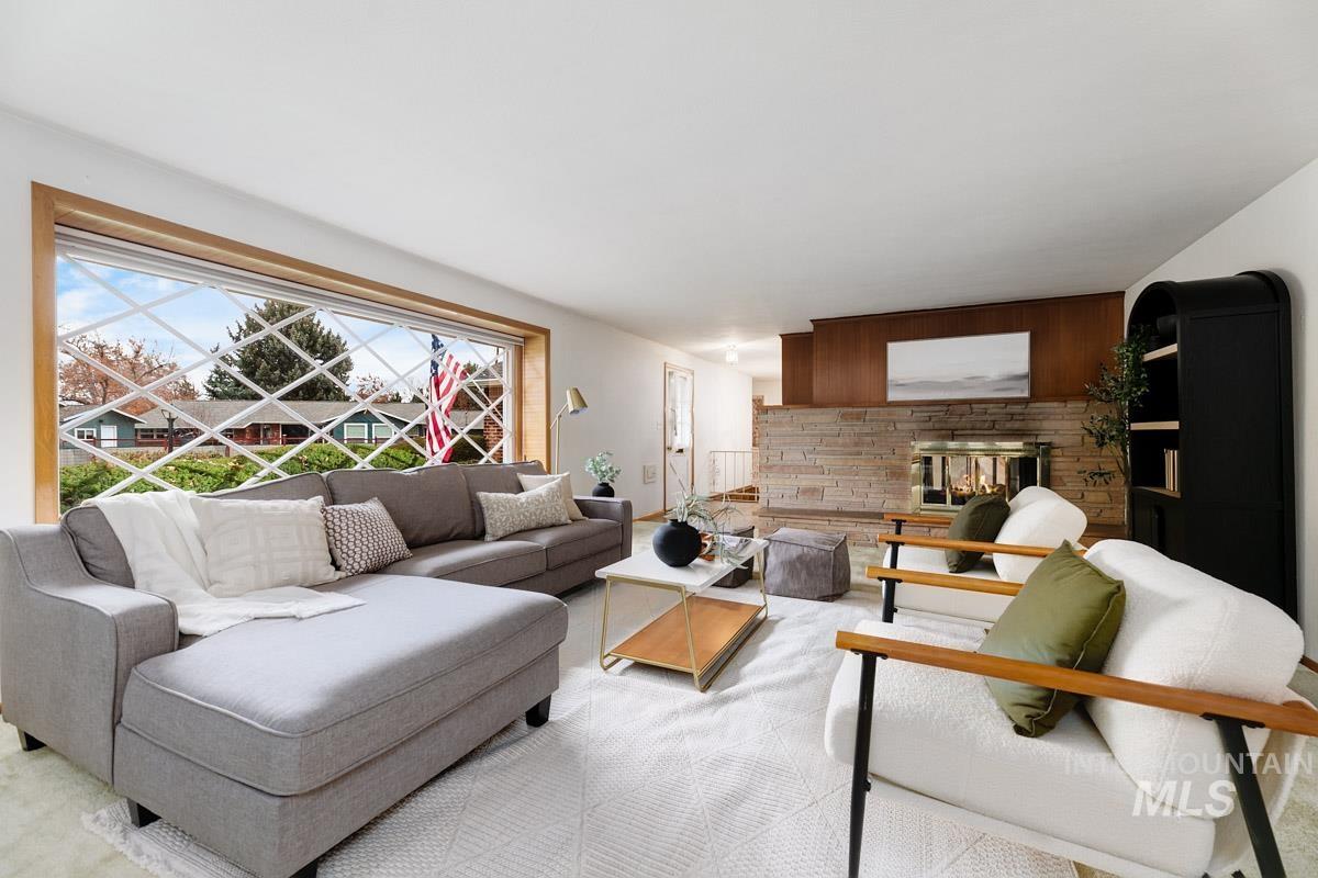 Living area with a stone fireplace and carpet floors