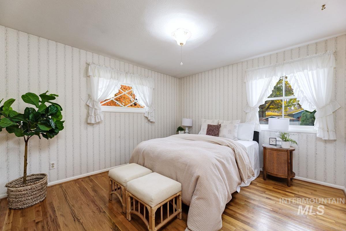 Bedroom featuring wallpapered walls and wood finished floors