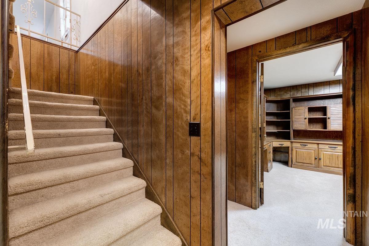 Stairway featuring carpet and wooden walls