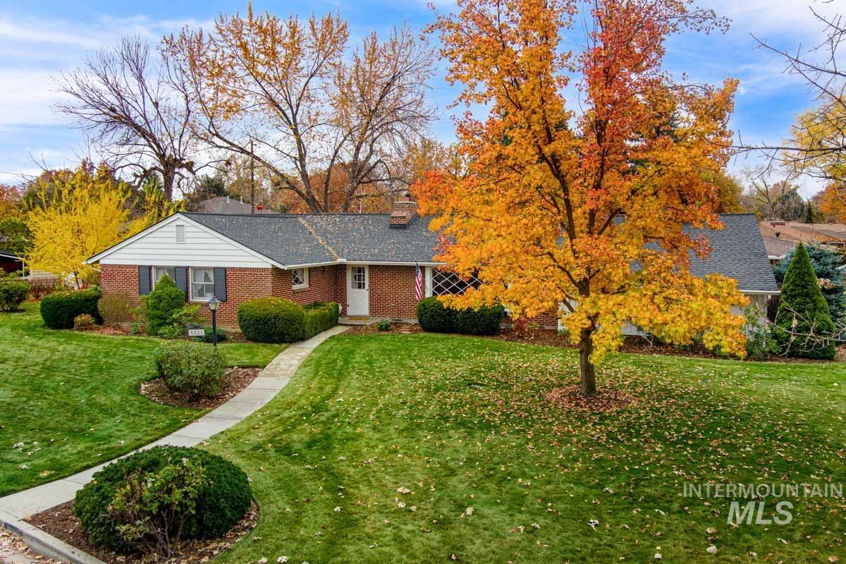 Ranch-style home with a front lawn, a chimney, and brick siding