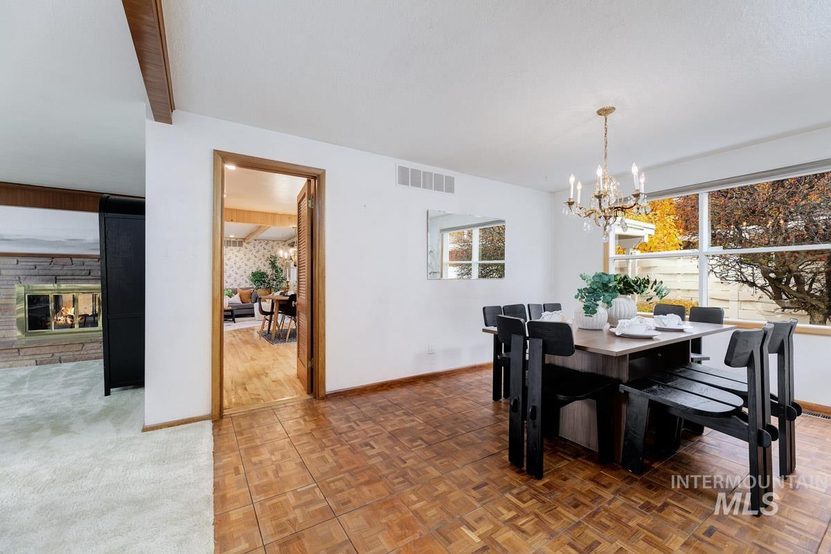 Dining room with a chandelier, plenty of natural light, and a stone fireplace