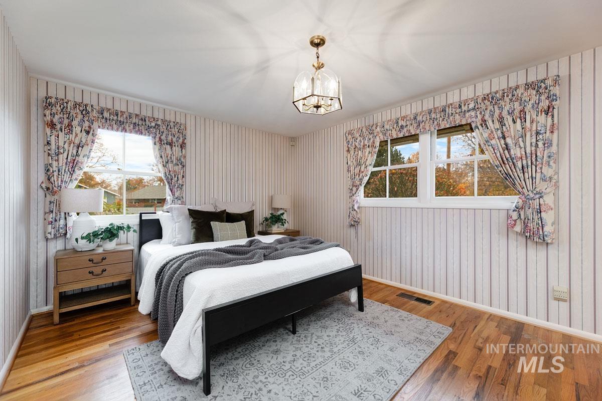 Bedroom featuring wood finished floors and a chandelier