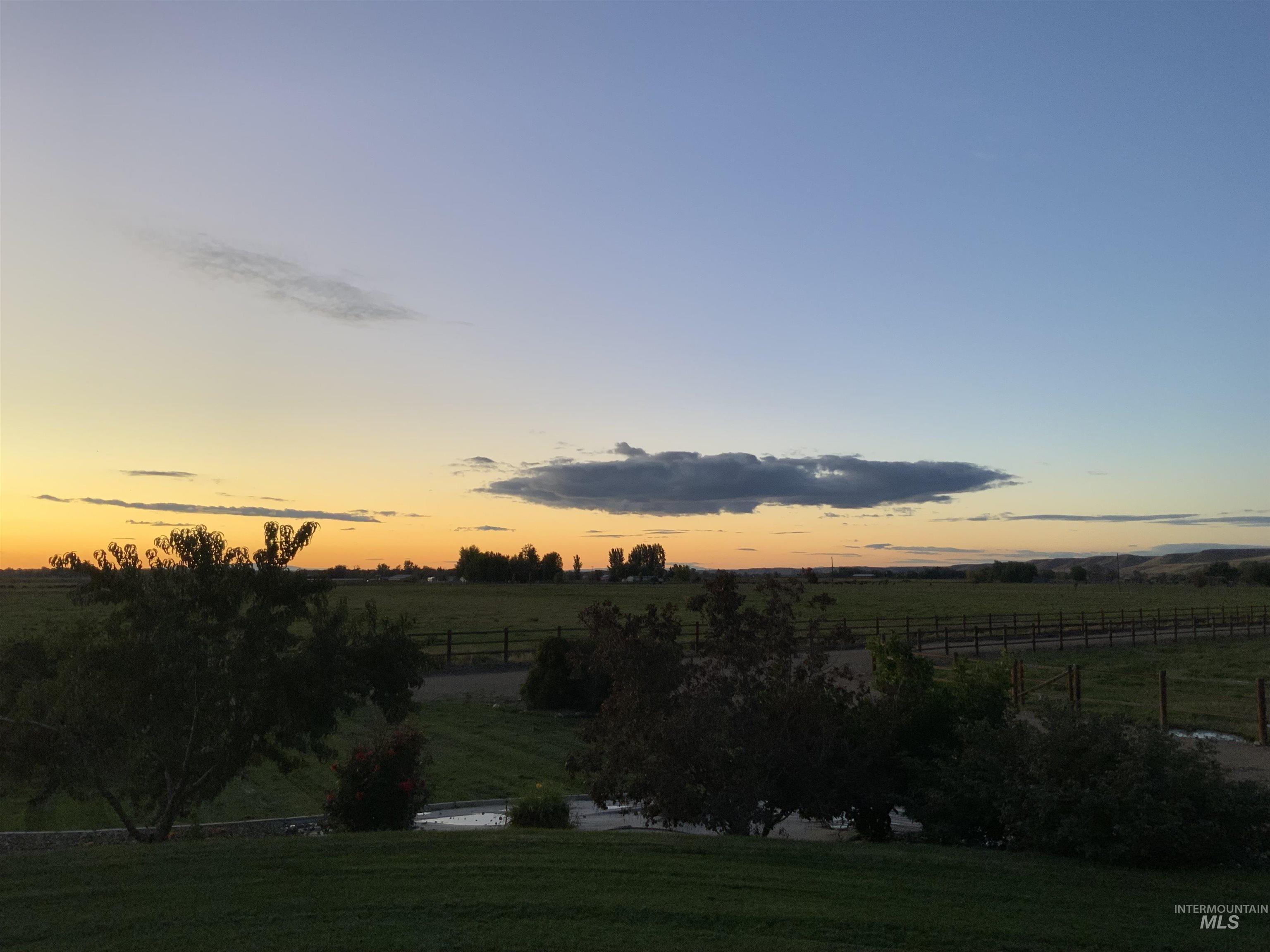 Yard at dusk featuring a view of rural / pastoral area