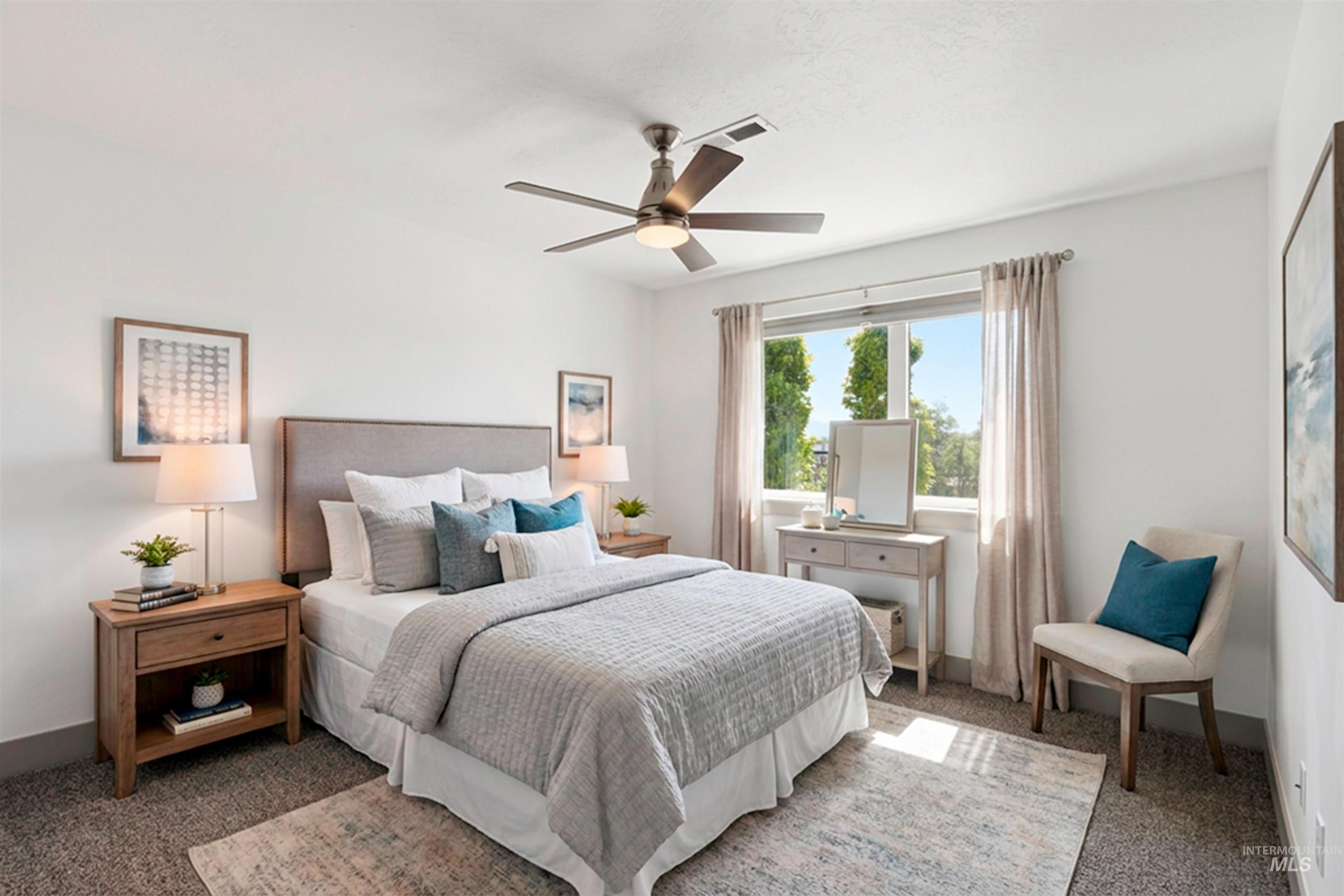 Carpeted bedroom featuring a large window, a ceiling fan with integrated lighting, and a textured headboard