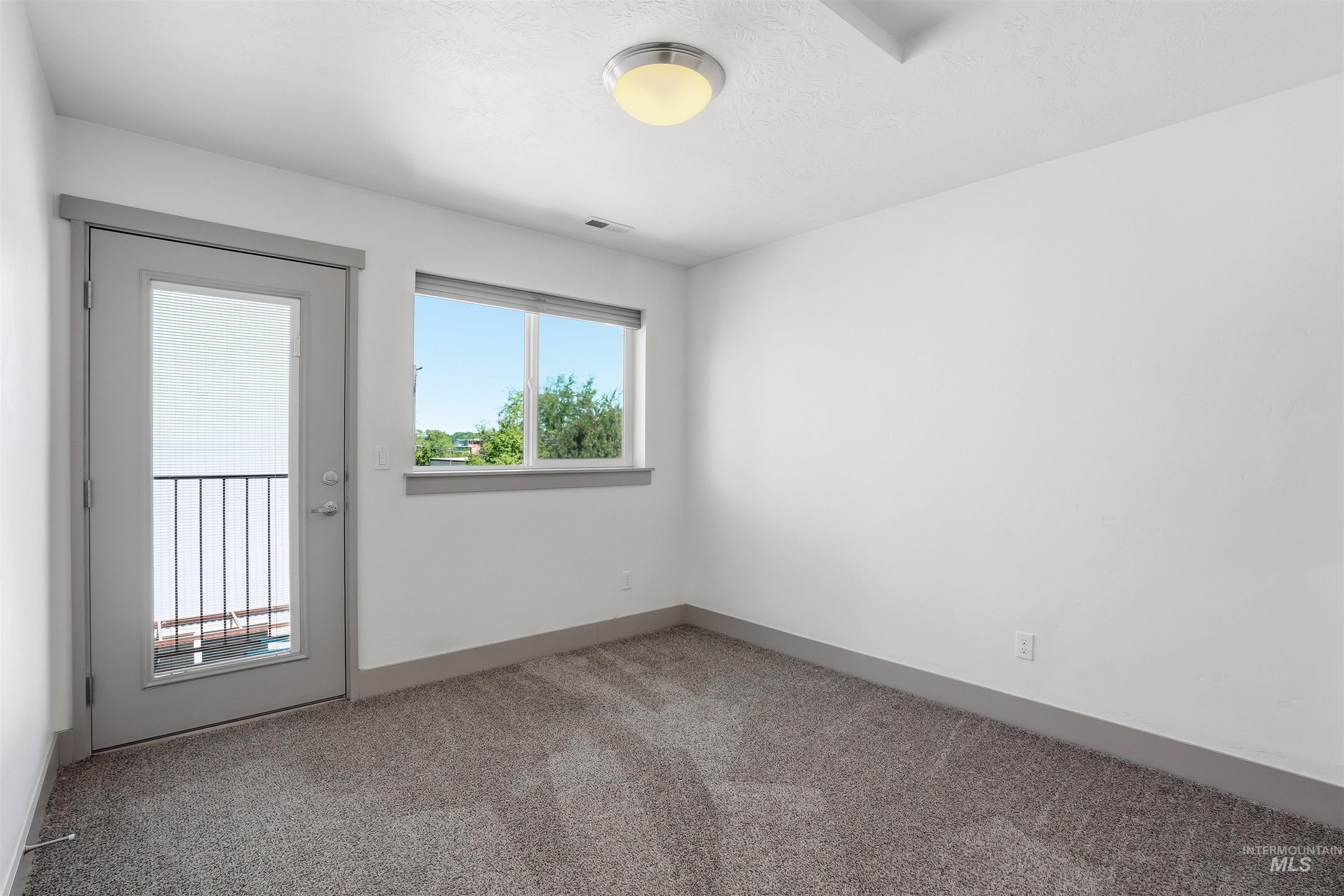 Room featuring a gray carpeted floor, white walls, and gray baseboards
