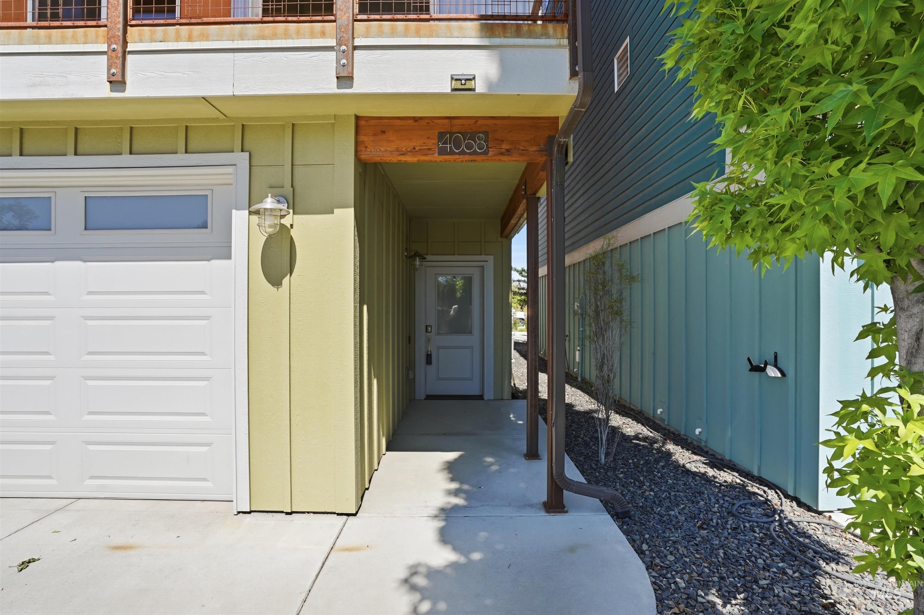Integrated garage with frosted transom windows, covered entryway, and wood-finish beam accents