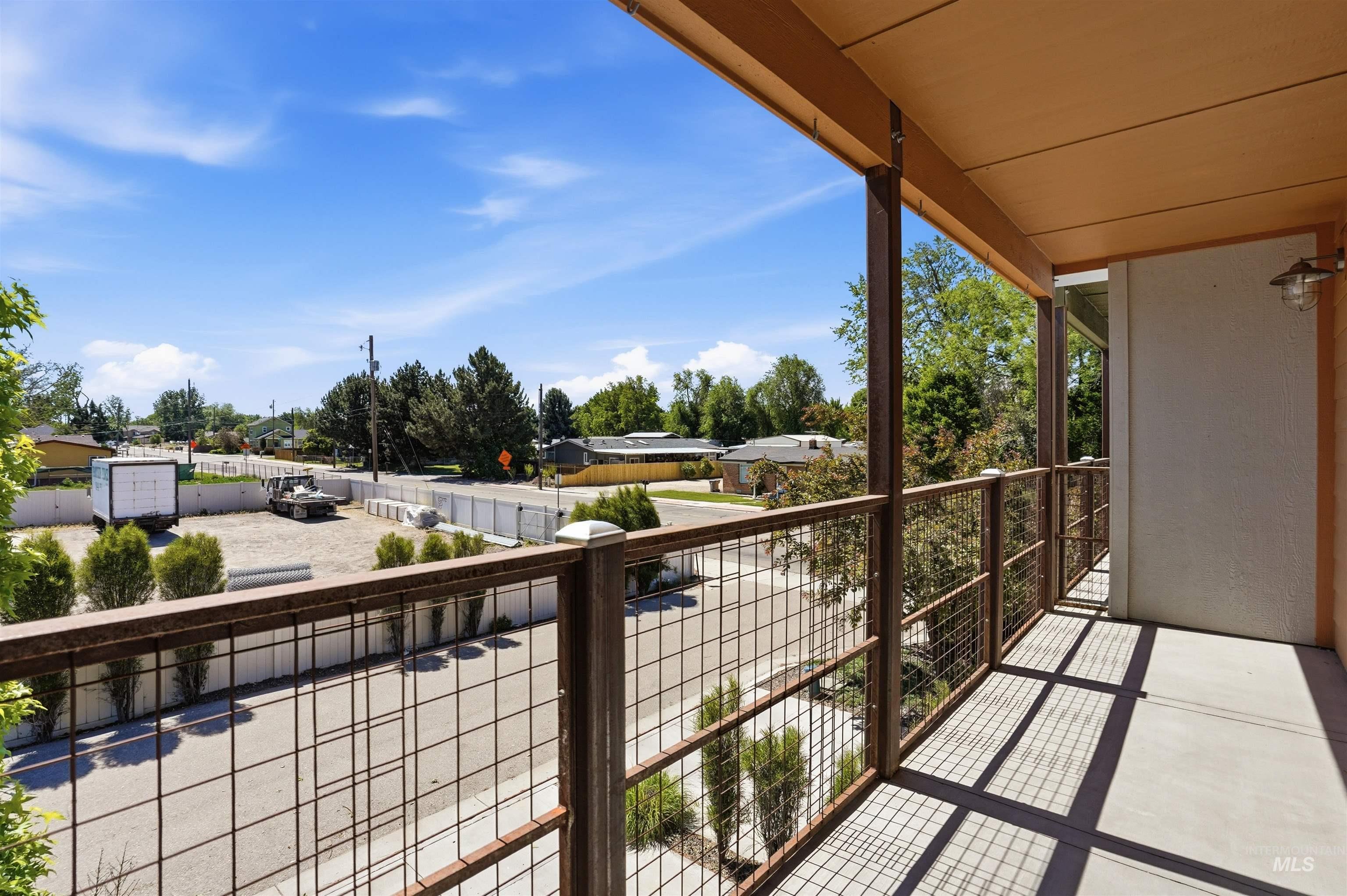 Covered balcony featuring concrete flooring and metal grid railing