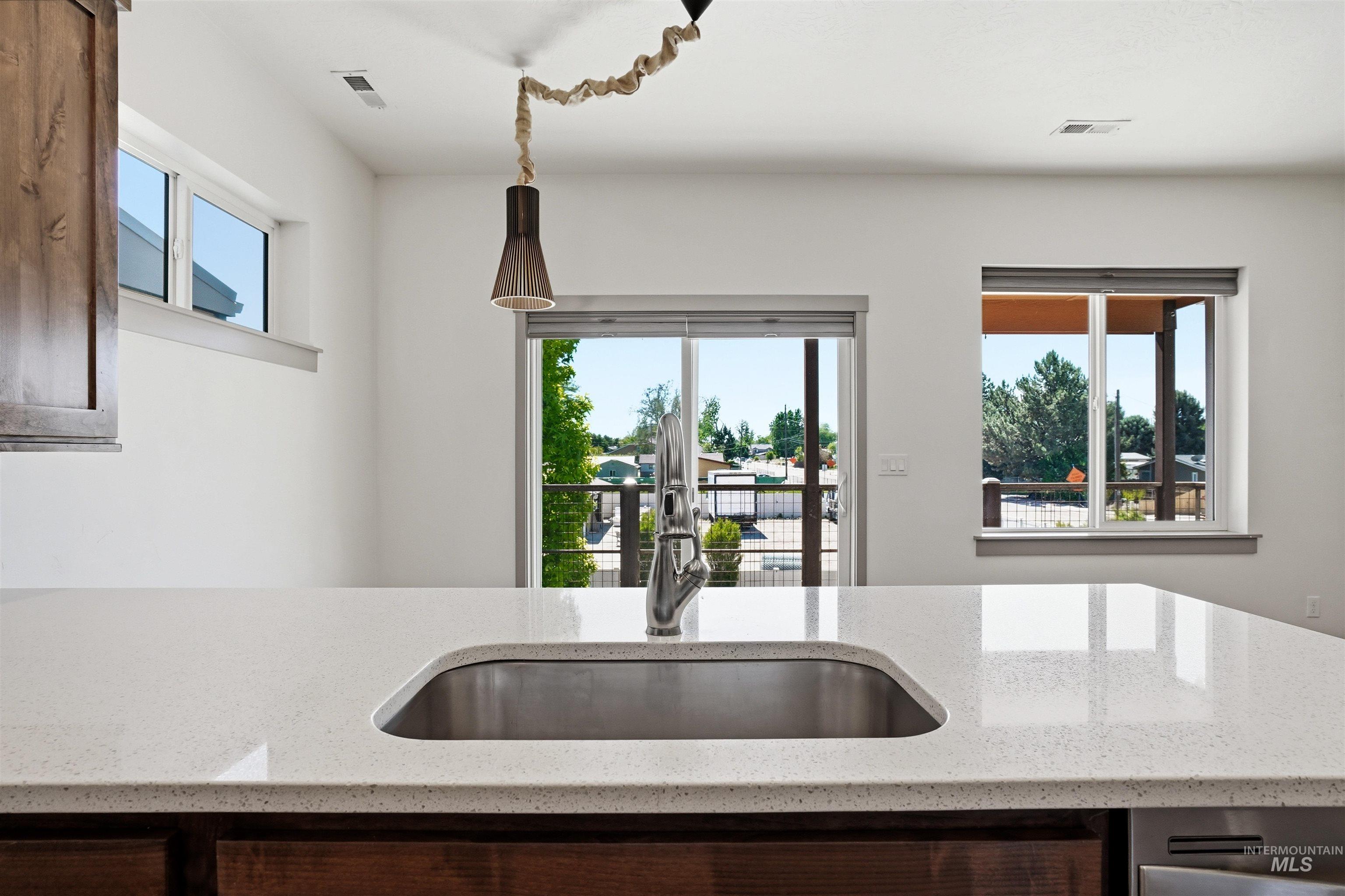 Kitchen island featuring a stainless steel sink with a gooseneck faucet