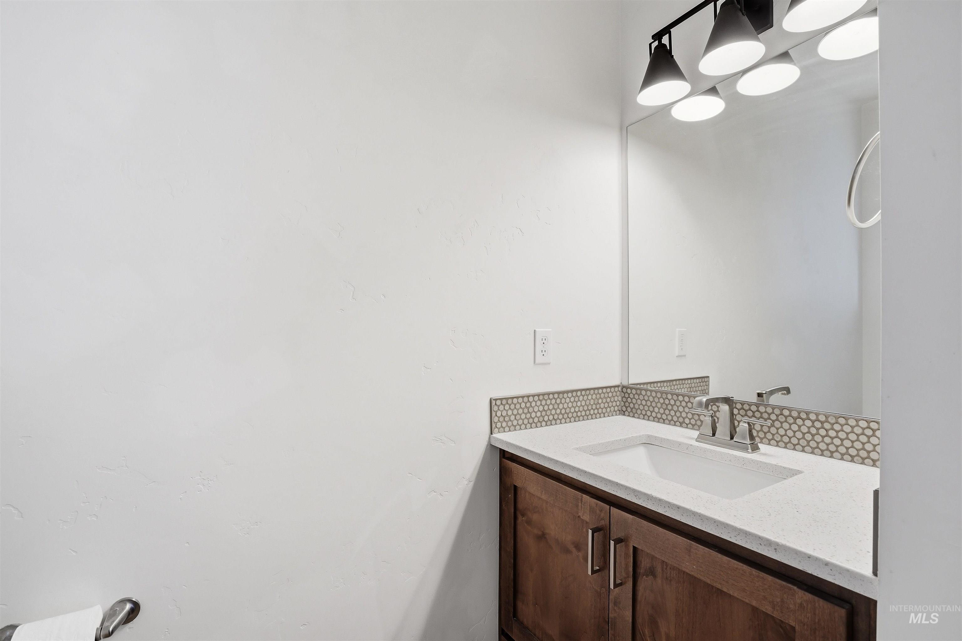 Vanity with a white integrated sink, chrome faucet, and quartz-finish countertop