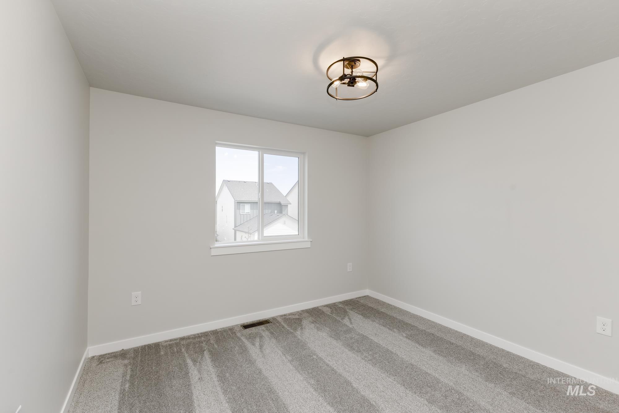 Spare room featuring carpet and baseboards