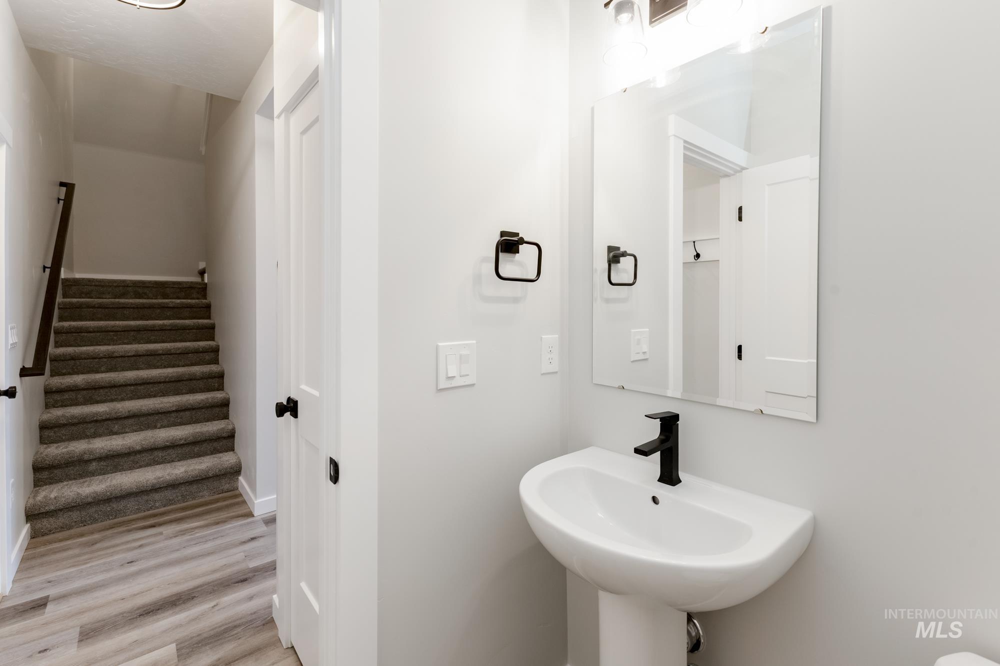 Half bathroom featuring light wood-style flooring and baseboards
