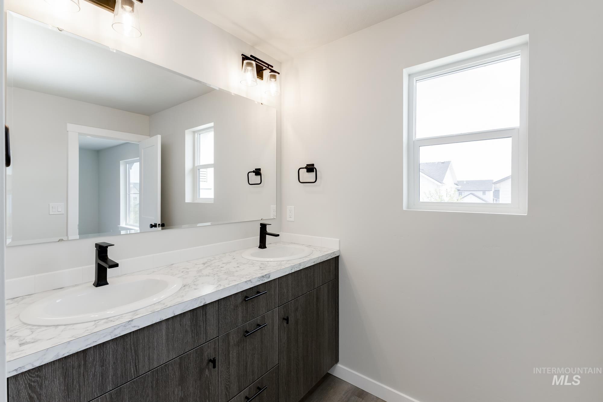 Bathroom featuring double vanity and baseboards