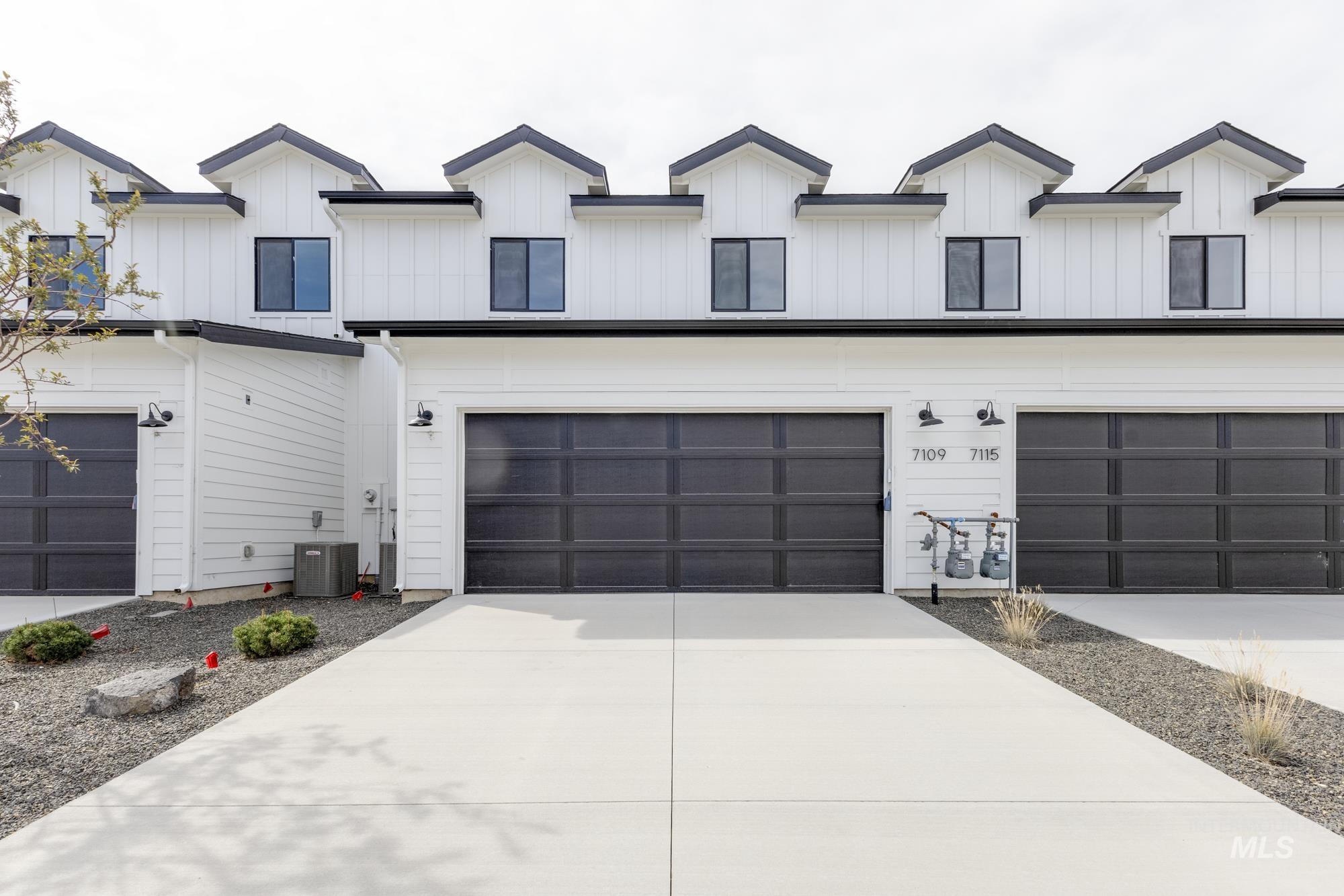View of front facade featuring driveway, an attached garage, and board and batten siding