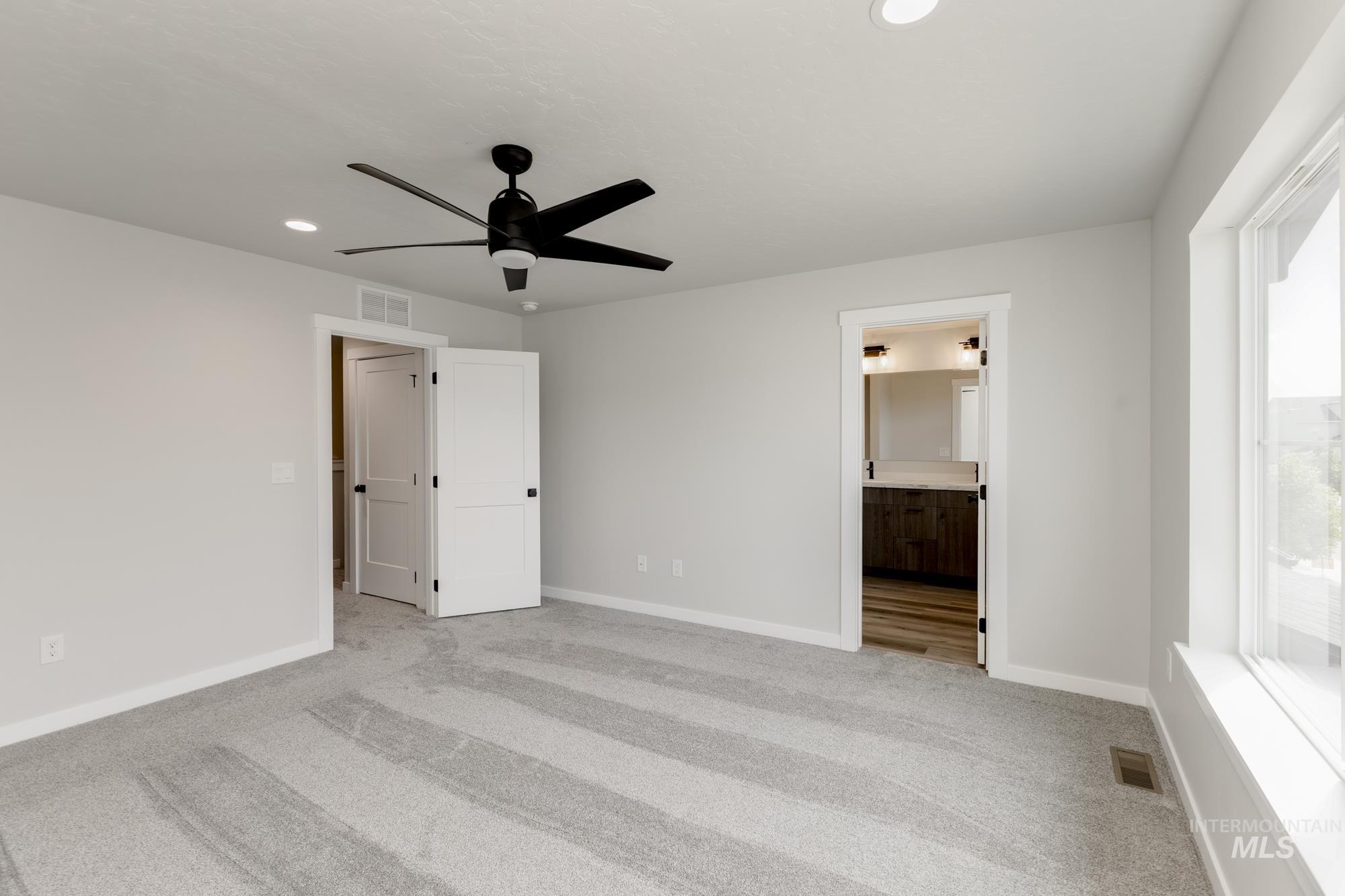 Unfurnished bedroom featuring light colored carpet, recessed lighting, ceiling fan, and connected bathroom