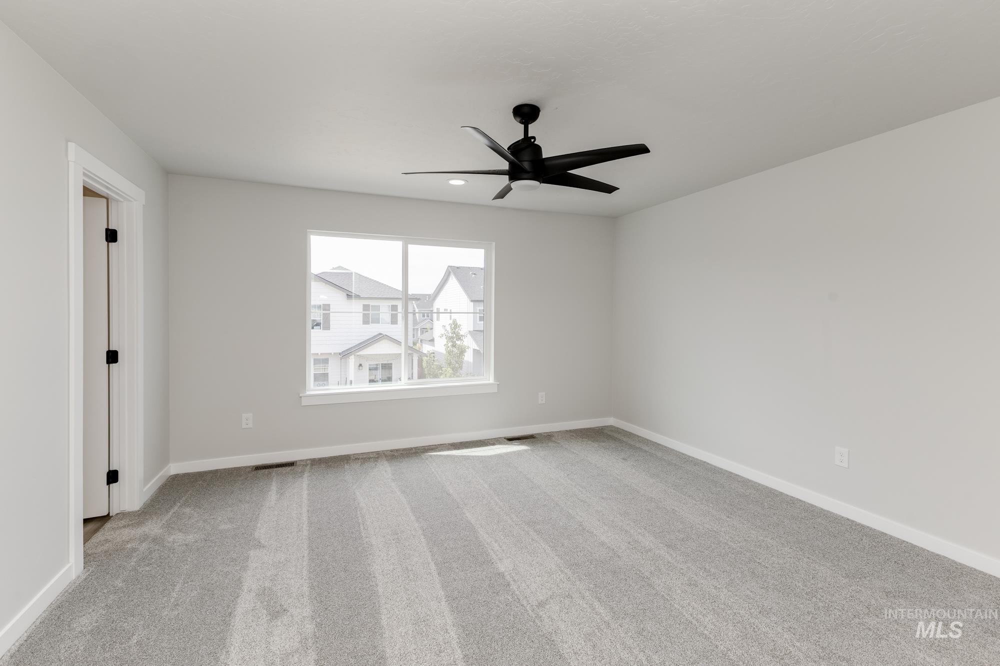 Spare room featuring light carpet and ceiling fan
