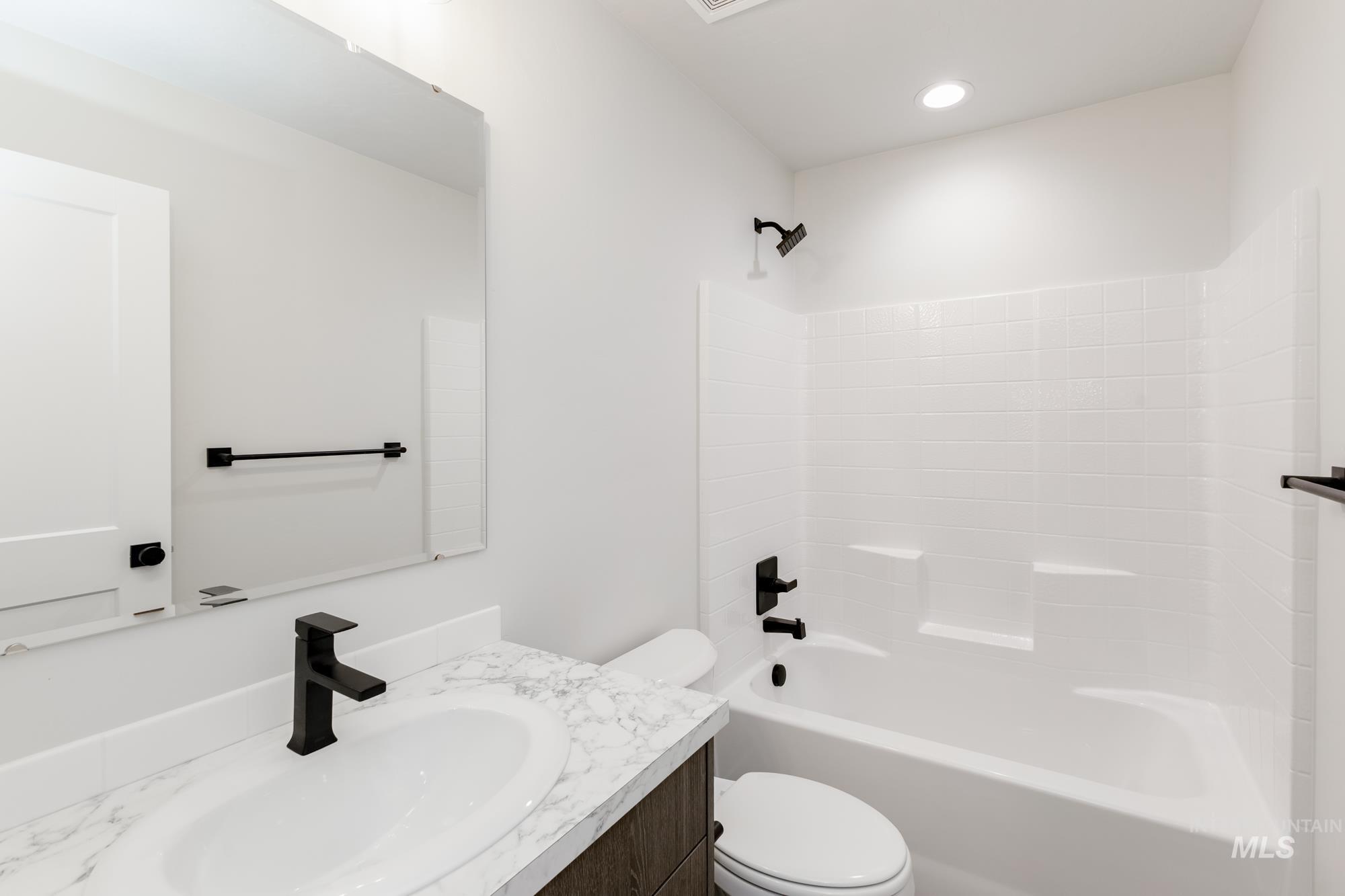 Bathroom featuring shower / bath combination, vanity, and recessed lighting