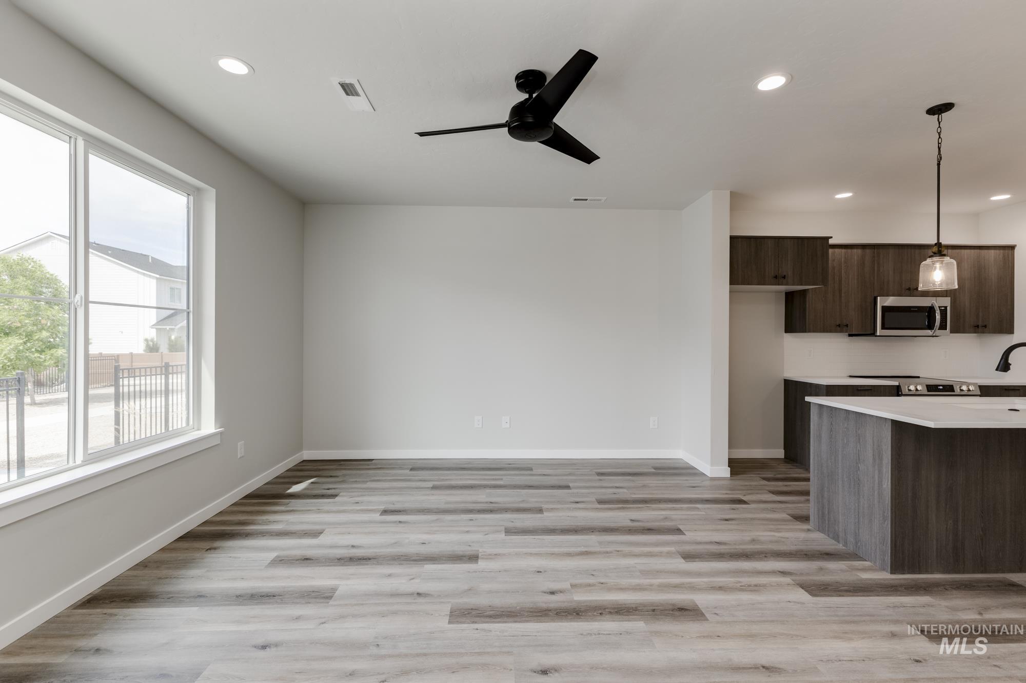 Kitchen featuring dark brown cabinetry, modern cabinets, light wood-type flooring, recessed lighting, and hanging light fixtures