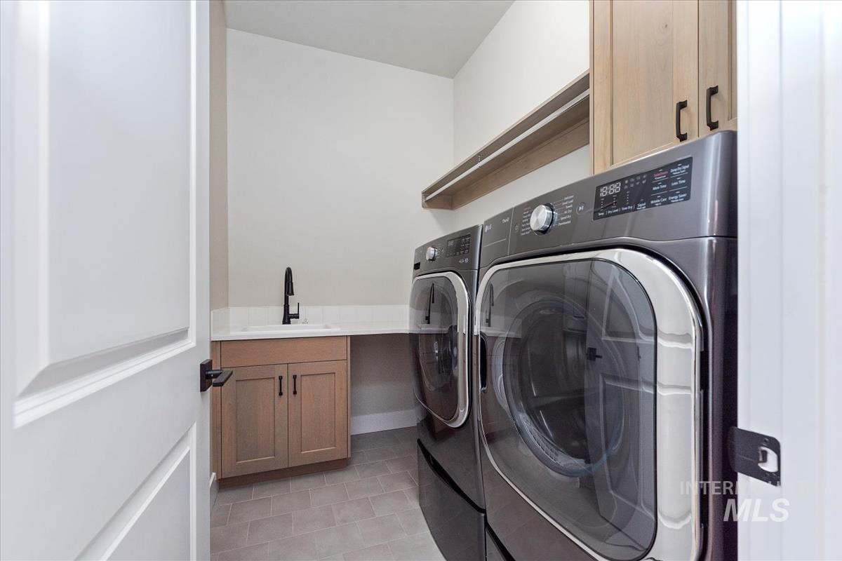 Laundry room with cabinet space, independent washer and dryer, and light tile patterned floors