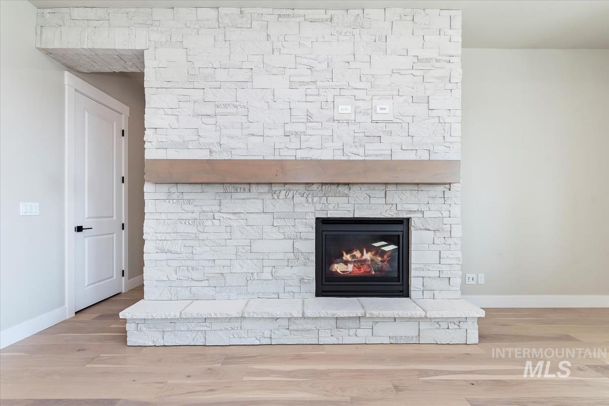Detailed view of wood finished floors and a fireplace