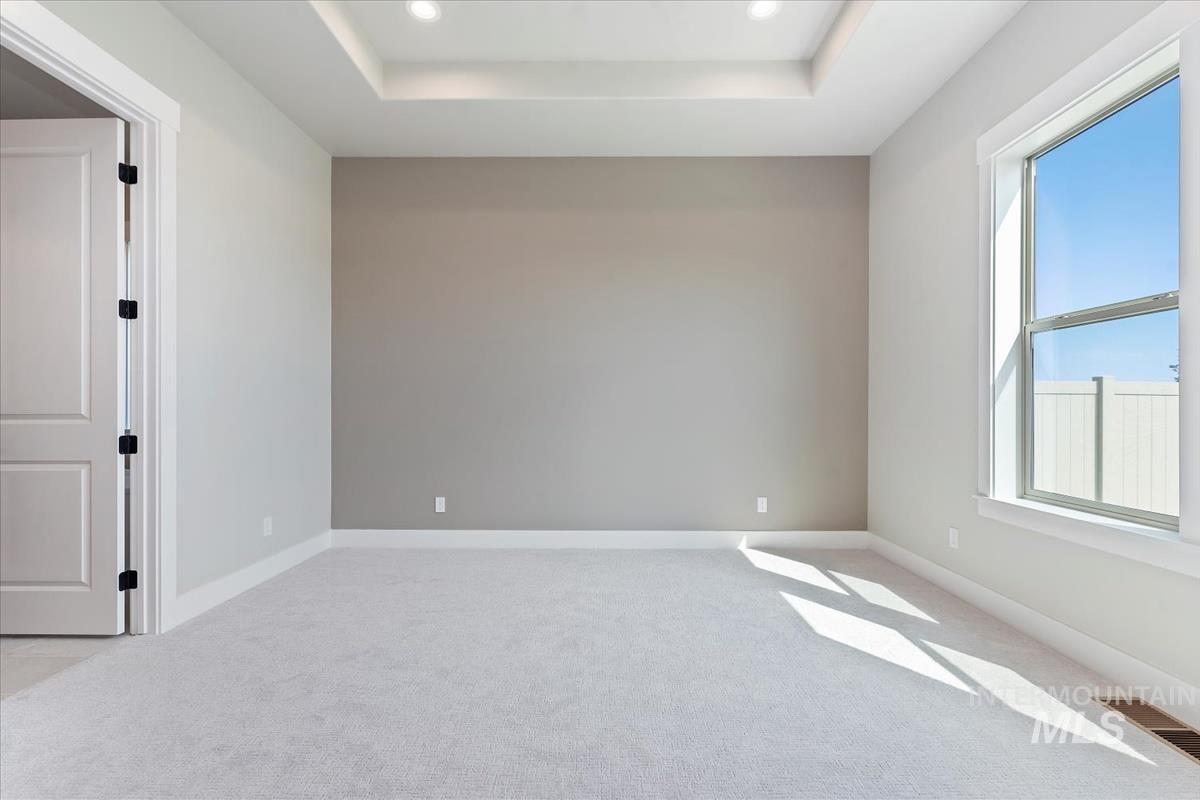 Unfurnished room featuring a tray ceiling, light colored carpet, and recessed lighting