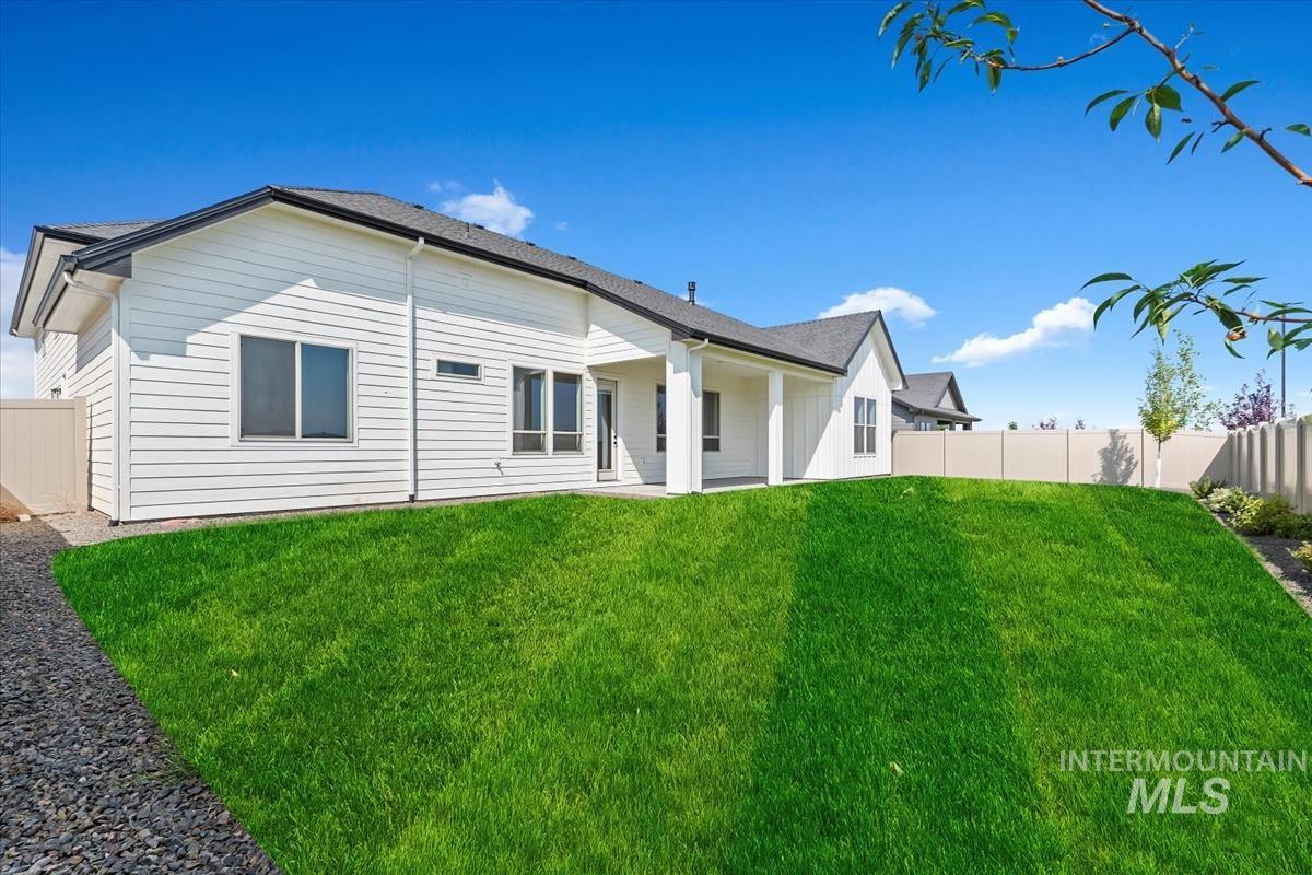 Rear view of property with a fenced backyard and a patio area