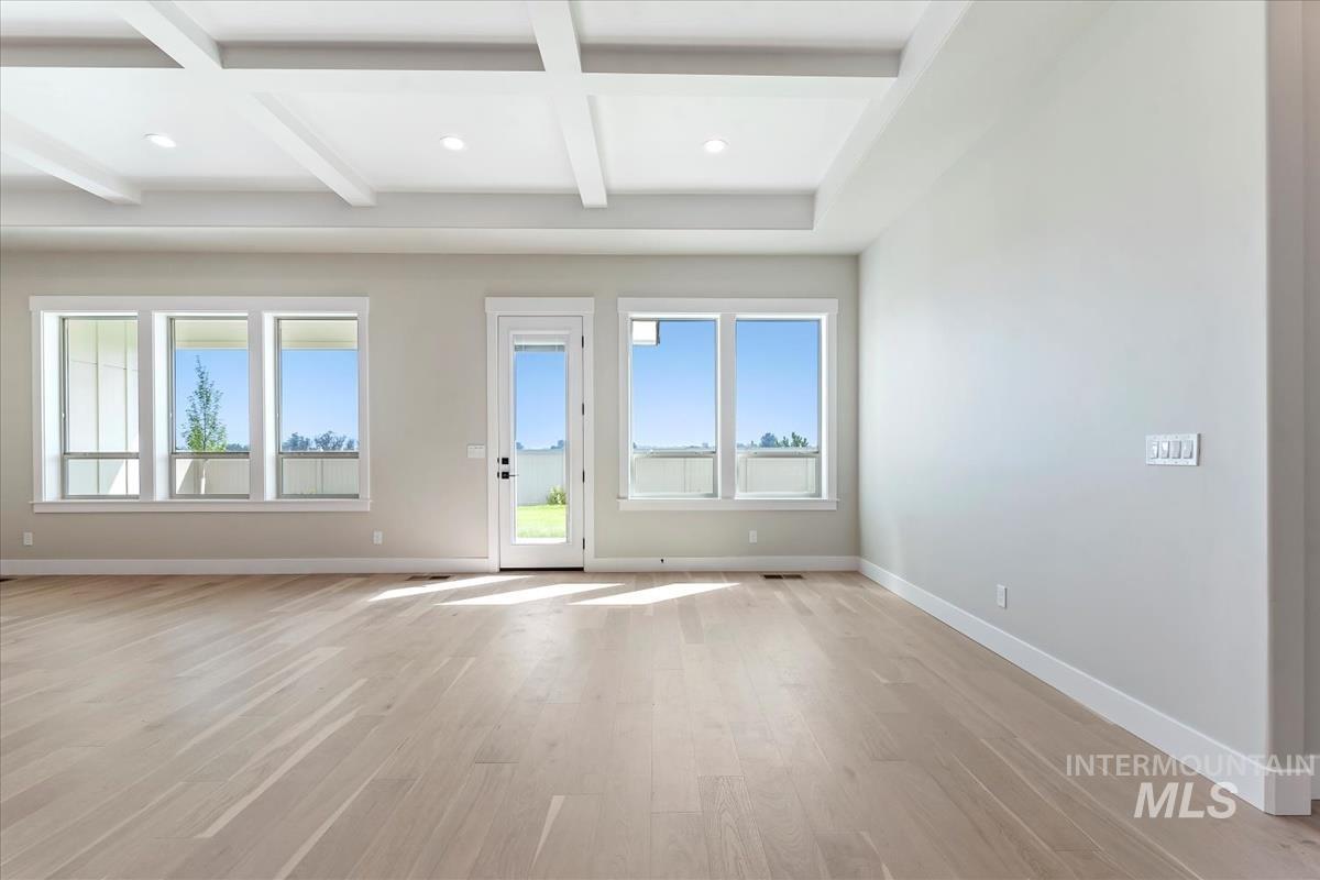 Spare room featuring beam ceiling, light wood-style flooring, coffered ceiling, and recessed lighting