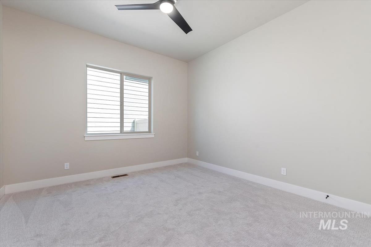 Unfurnished room with light carpet and a ceiling fan