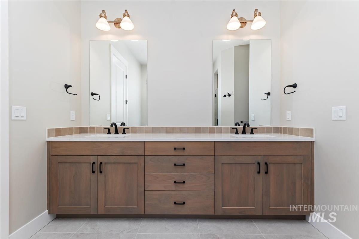Full bathroom with double vanity and light tile patterned floors