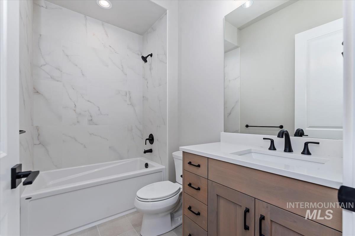 Full bathroom featuring shower / bathtub combination, vanity, light tile patterned floors, and recessed lighting