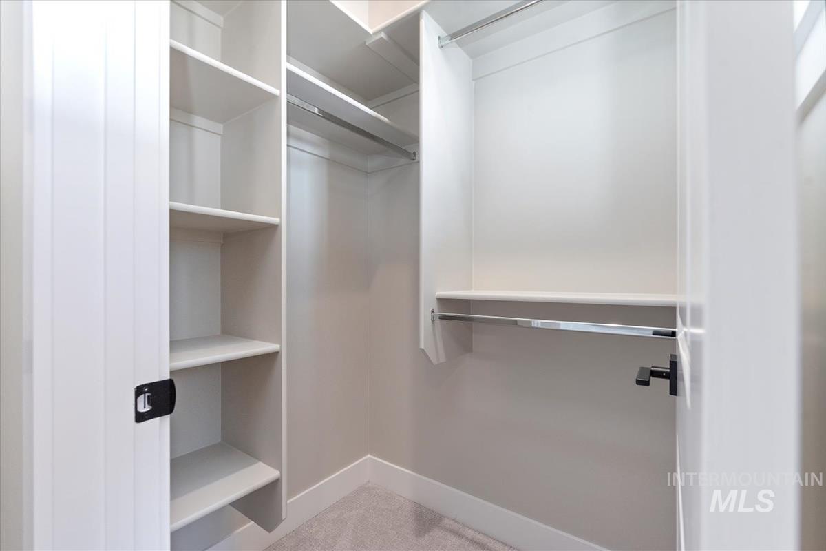 Walk in closet featuring light colored carpet