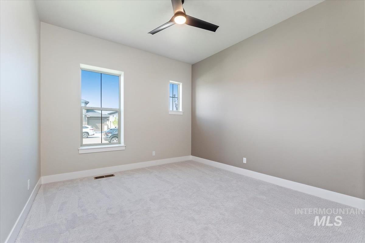 Unfurnished room with light colored carpet and ceiling fan