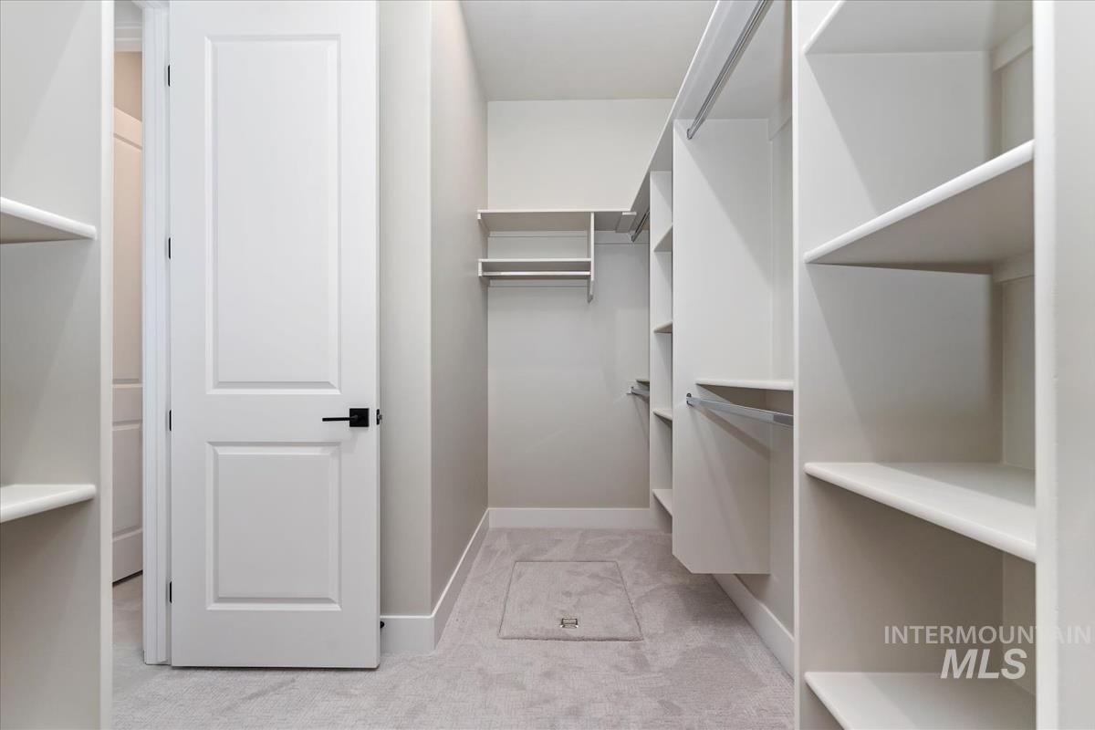 Spacious closet with light carpet