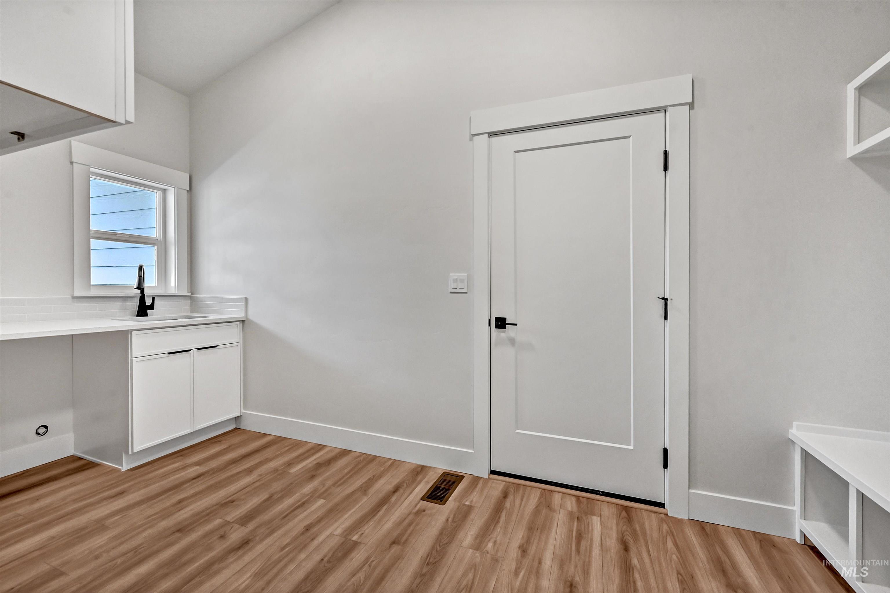 Washroom featuring light wood finished floors and baseboards