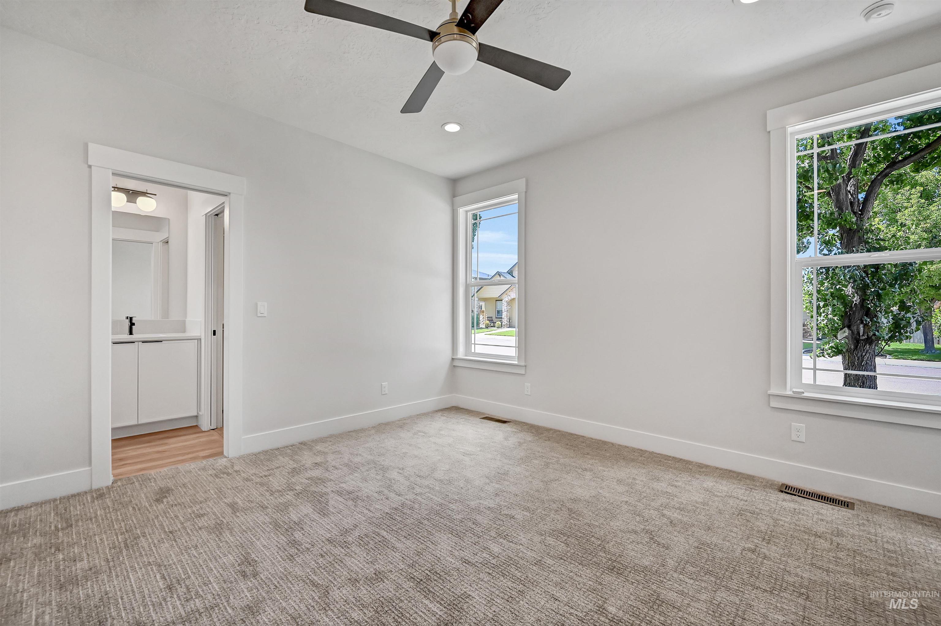 Empty room featuring light colored carpet, a ceiling fan, and recessed lighting