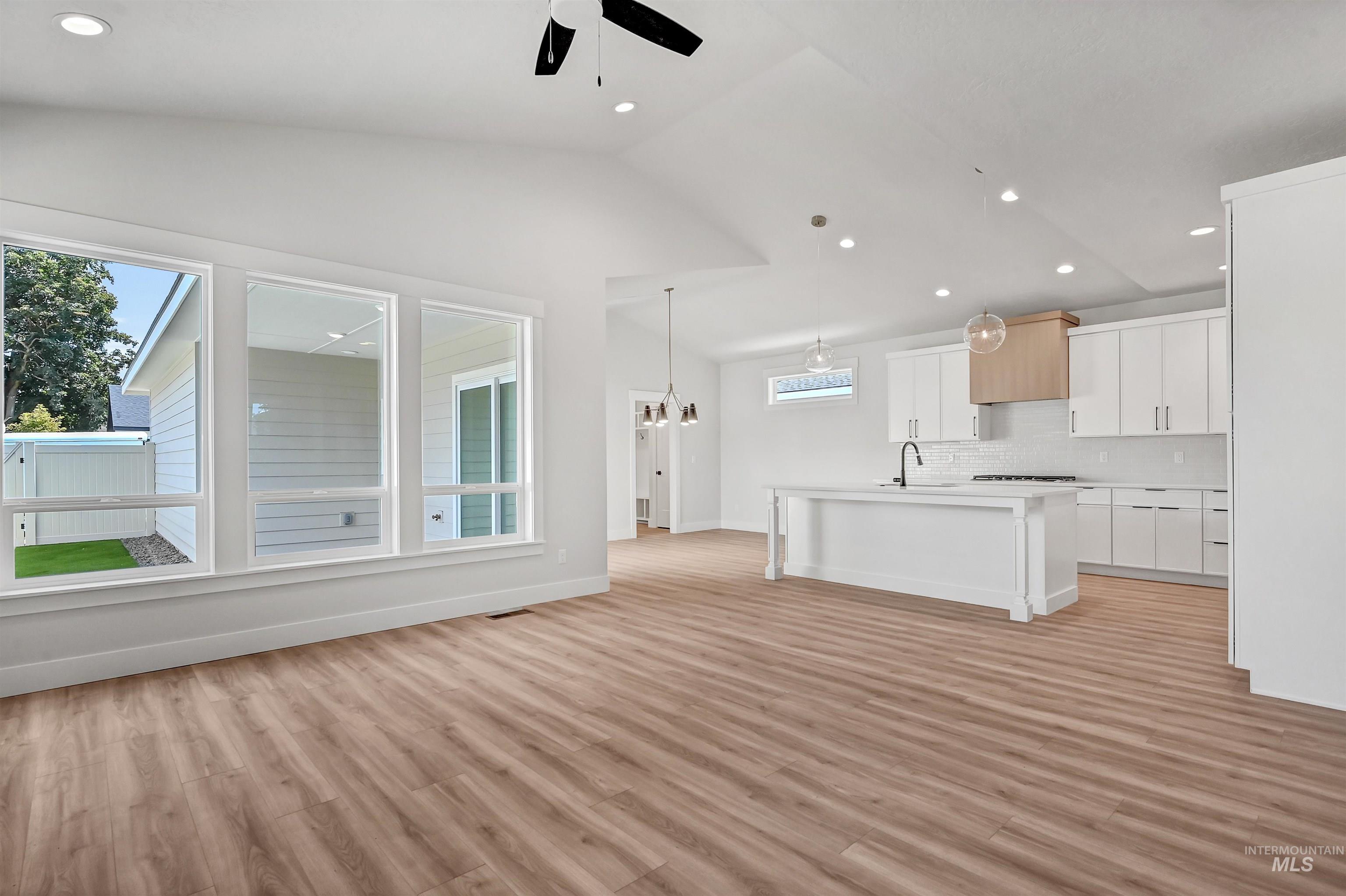 Kitchen with white cabinetry, light countertops, recessed lighting, a center island with sink, and pendant lighting
