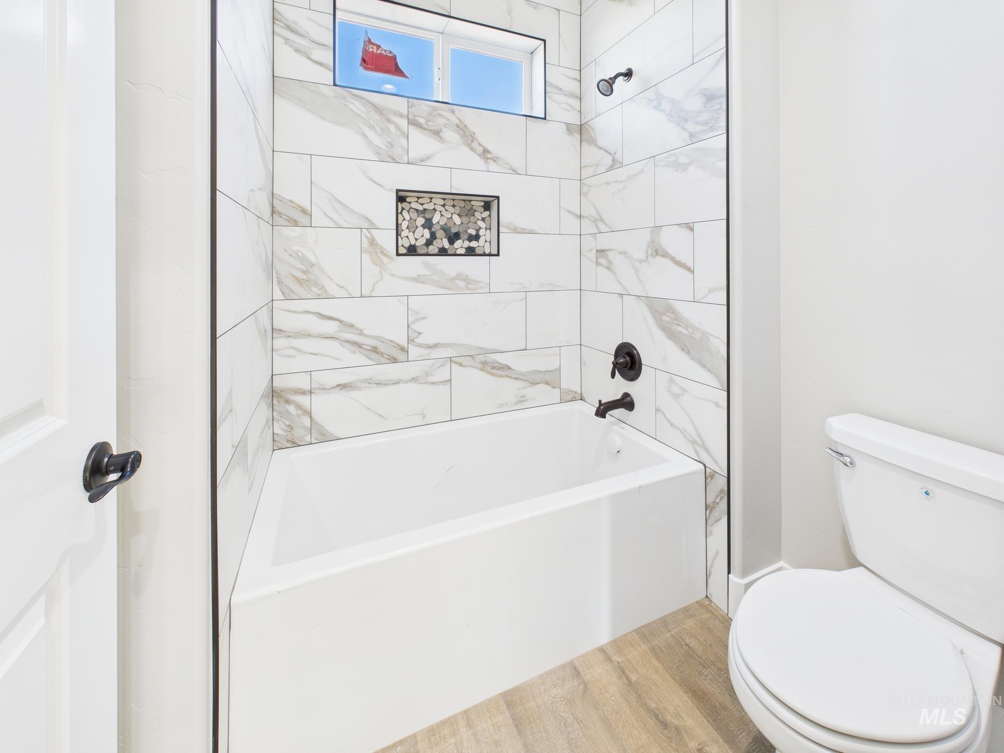 Bathroom featuring shower / tub combination and light wood finished floors