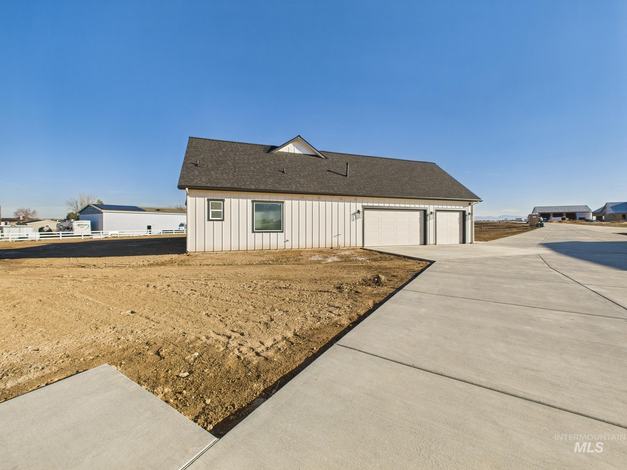View of home's exterior featuring a garage, a shingled roof, and concrete driveway